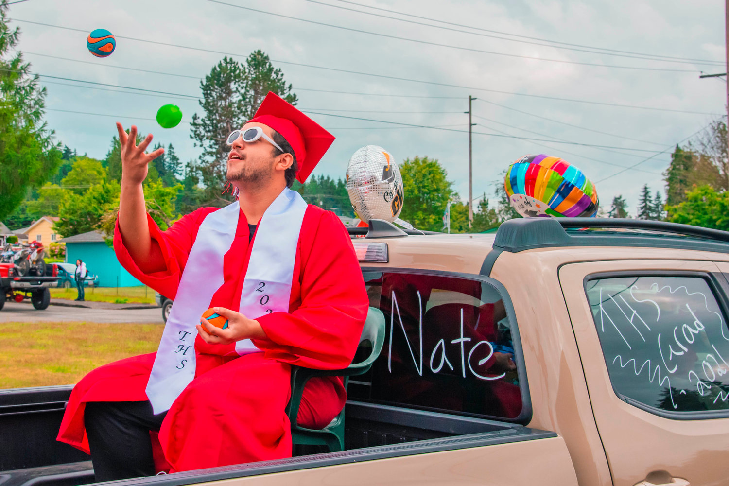 Nate, a Tenino graduate, sports sunglasses and juggles during a parade ceremony for the Class of 2021.
