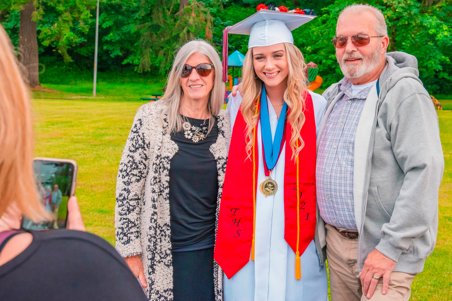 Salutatorian Autumn Long smiles and poses with grandparents while her mother takes a photo Friday at Tenino City Park.