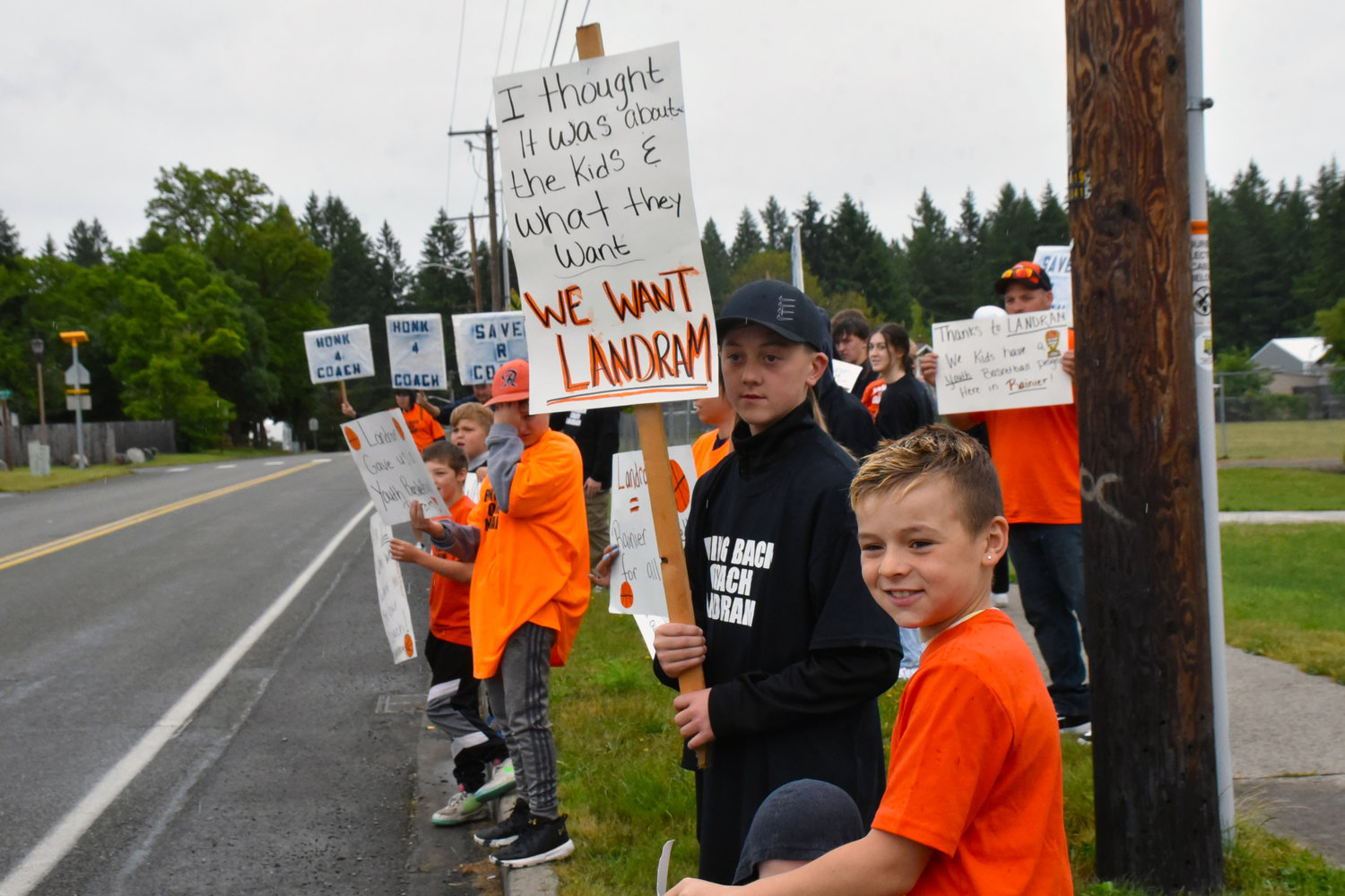 Dozens of citizens protested the Rainier School District’s decision to not renew Jeremy Landram’s coaching contract on Monday, June 14, outside of the district office.