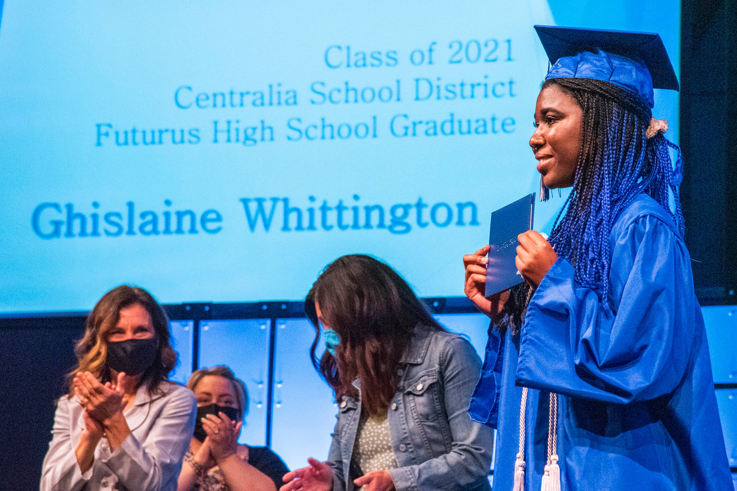 Ghislaine Whittington smiles and holds up her diploma during the Futurus High School graduation ceremony in Centralia on Tuesday.