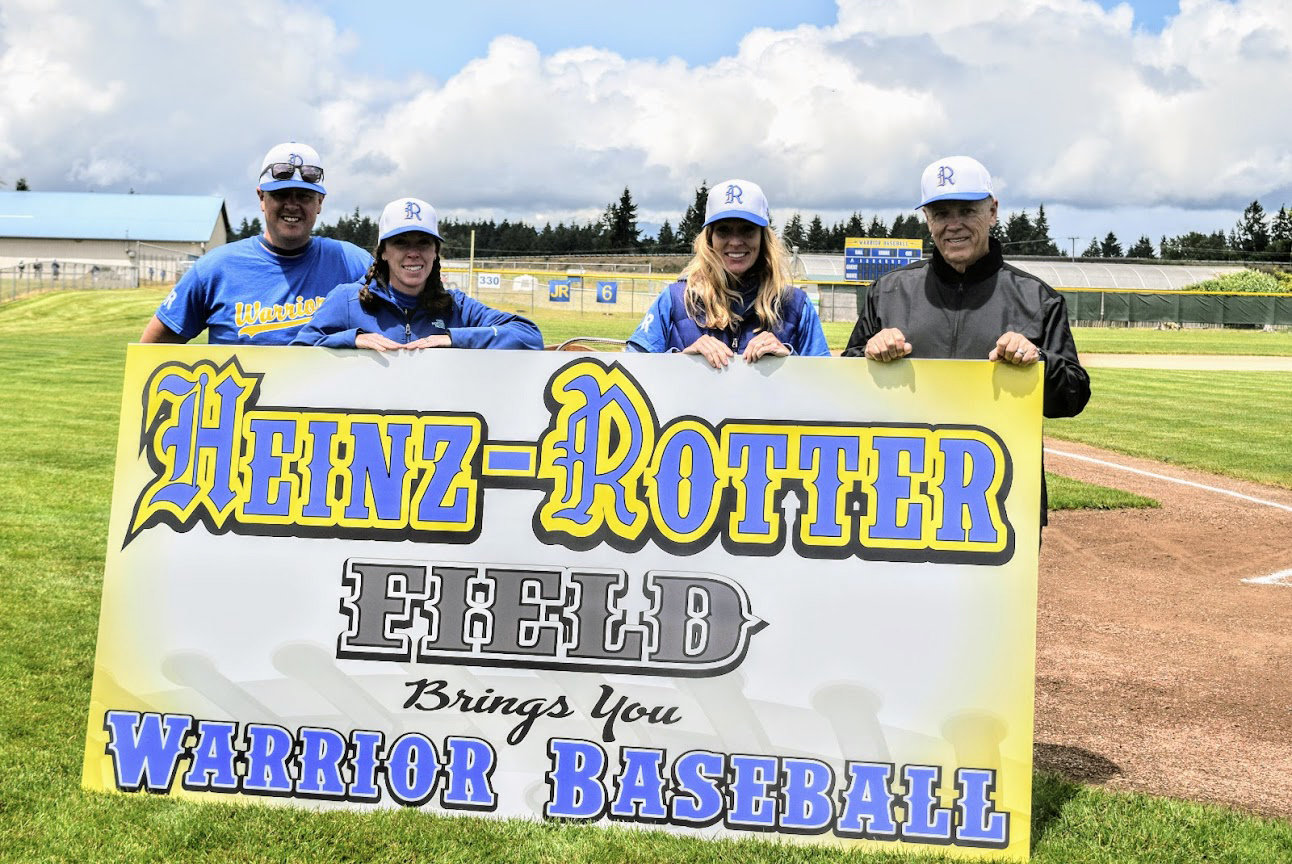 The sign for the rededication of Rochester's baseball field on June 5 to honor former teacher and coach Justin Rotter. From left, Rochester baseball coach Brad Quarnstrom, Jill Rotter (Justin's wife), Nicole Breuer (Jill's sister) and former coach Larry Heinz.