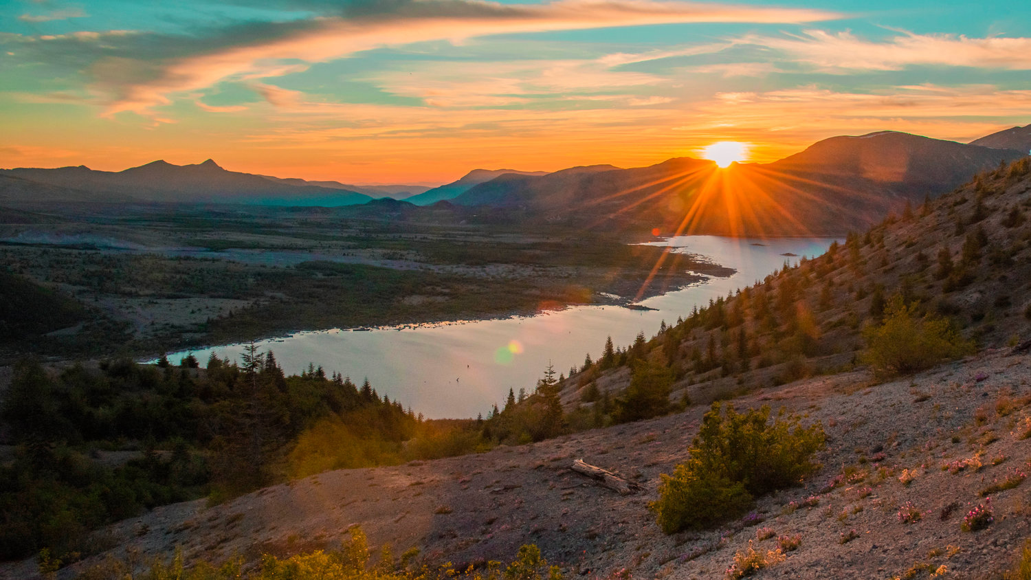 The sun sets behind foothills over Spirit Lake seen from the Windy Ridge Trail on Thursday near Mount St. Helens.