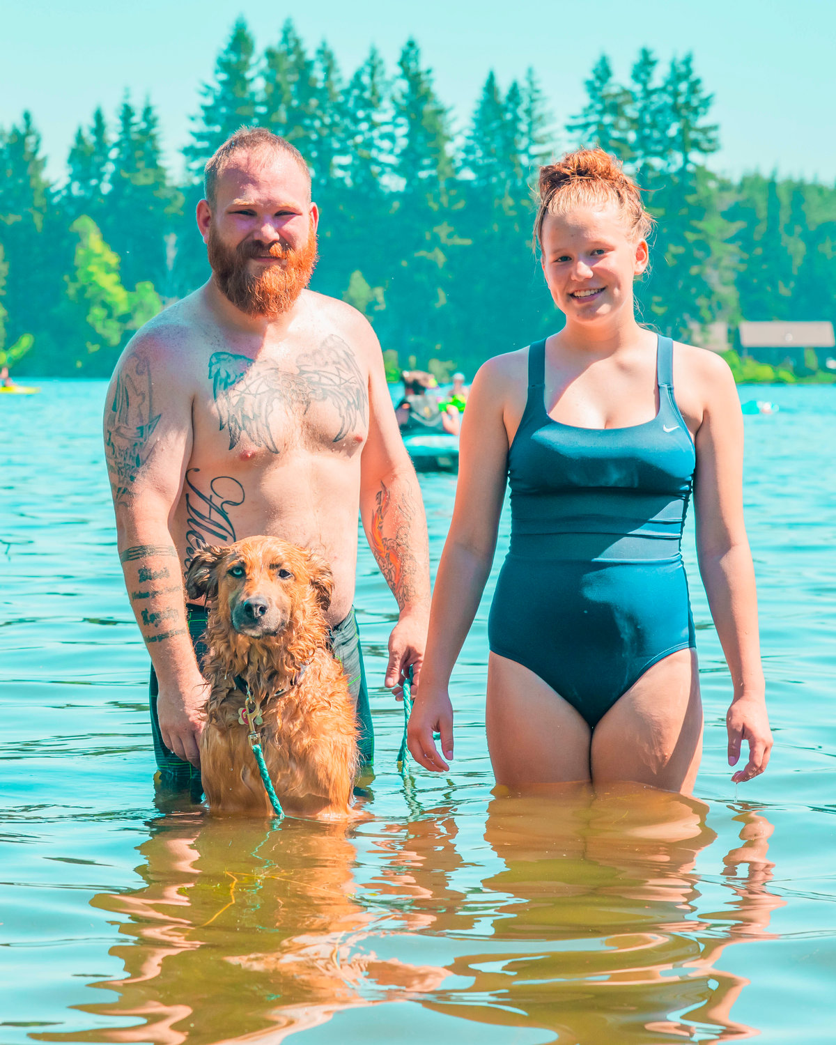Chip and Alexis pose with their dog Dixie, a Shepherd mix, while cooling off in Deep Lake at Millersylvania State Park on Sunday.