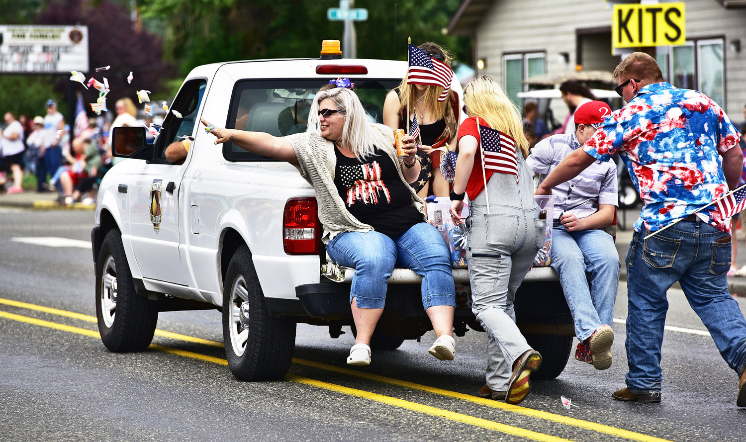 With a neat flick of the wrist, a woman tosses a handful of candy to waiting spectators during Oakville’s Independence Day parade on Saturday, July 3.