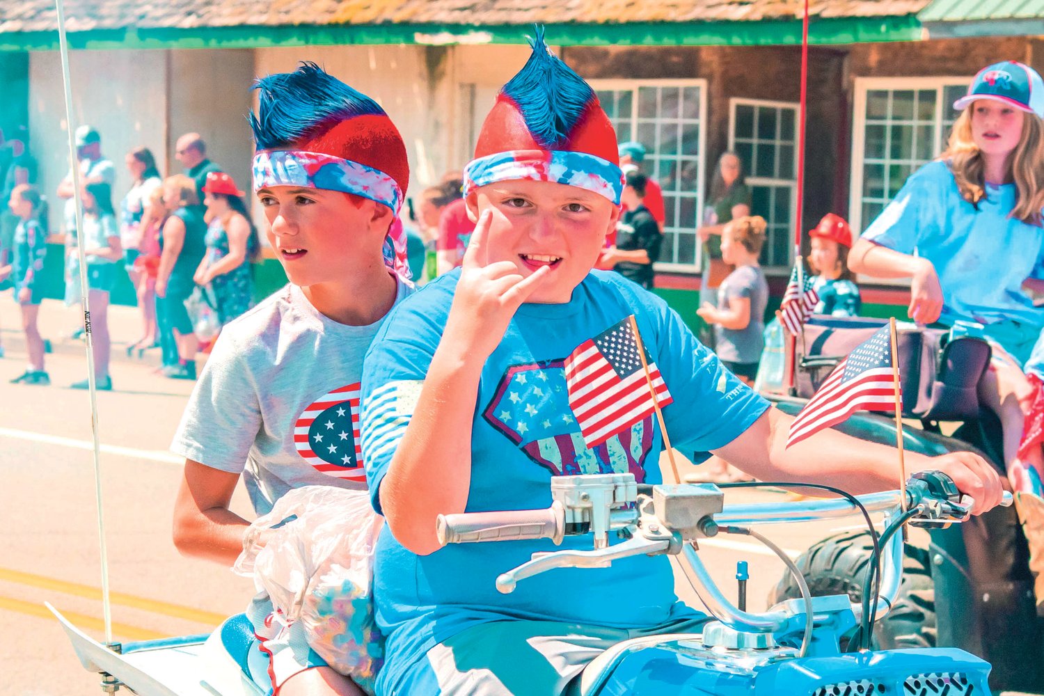 Riders decked out in red, white, and blue attire throw candy from atop a quad during the Pe Ell Fourth of July parade Sunday afternoon.