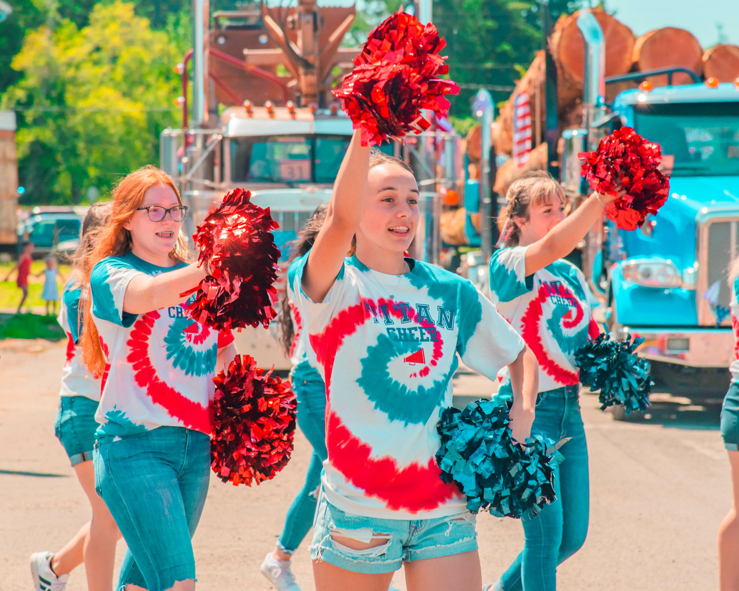 Members of the Titan cheer squad raise their poms during the Pe Ell Fourth of July parade Sunday afternoon.