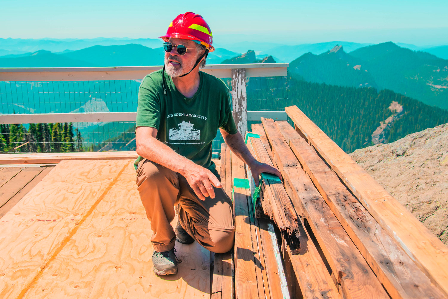 Rick McClure talks about decaying wood at High Rock Lookout during a Sand Mountain Society restoration project Tuesday in the Gifford Pinchot National Forest.