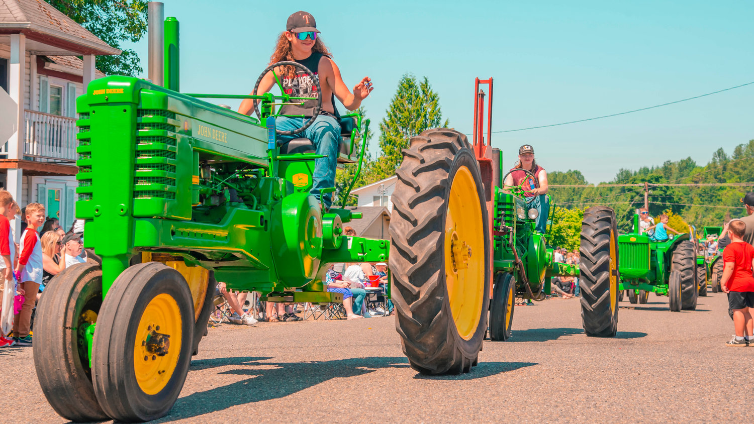John Deere tractors roll through Toledo during the Cheese Days parade on Saturday.