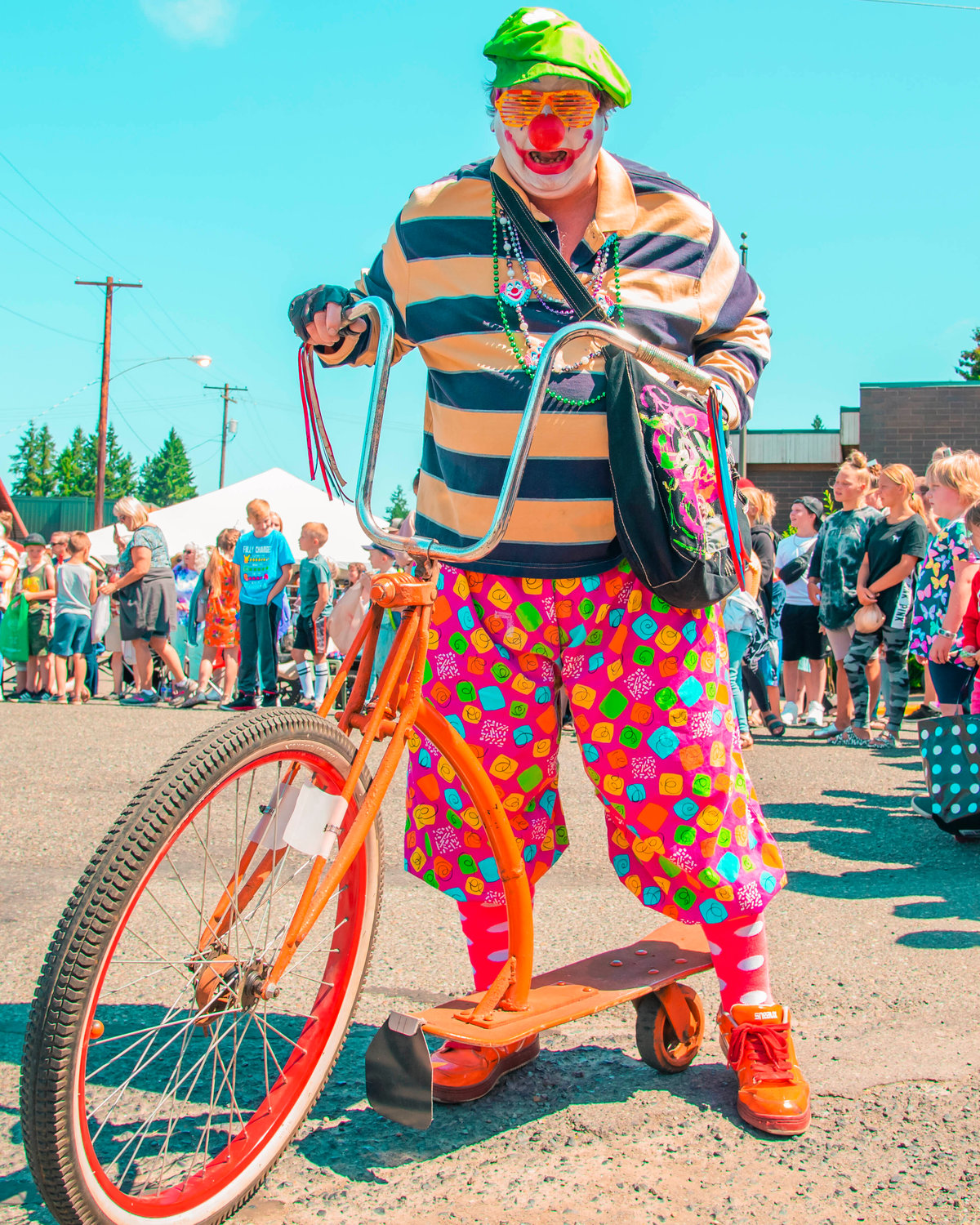An Astoria Clown rides by crowds during the Toledo Cheese Days parade on Saturday.