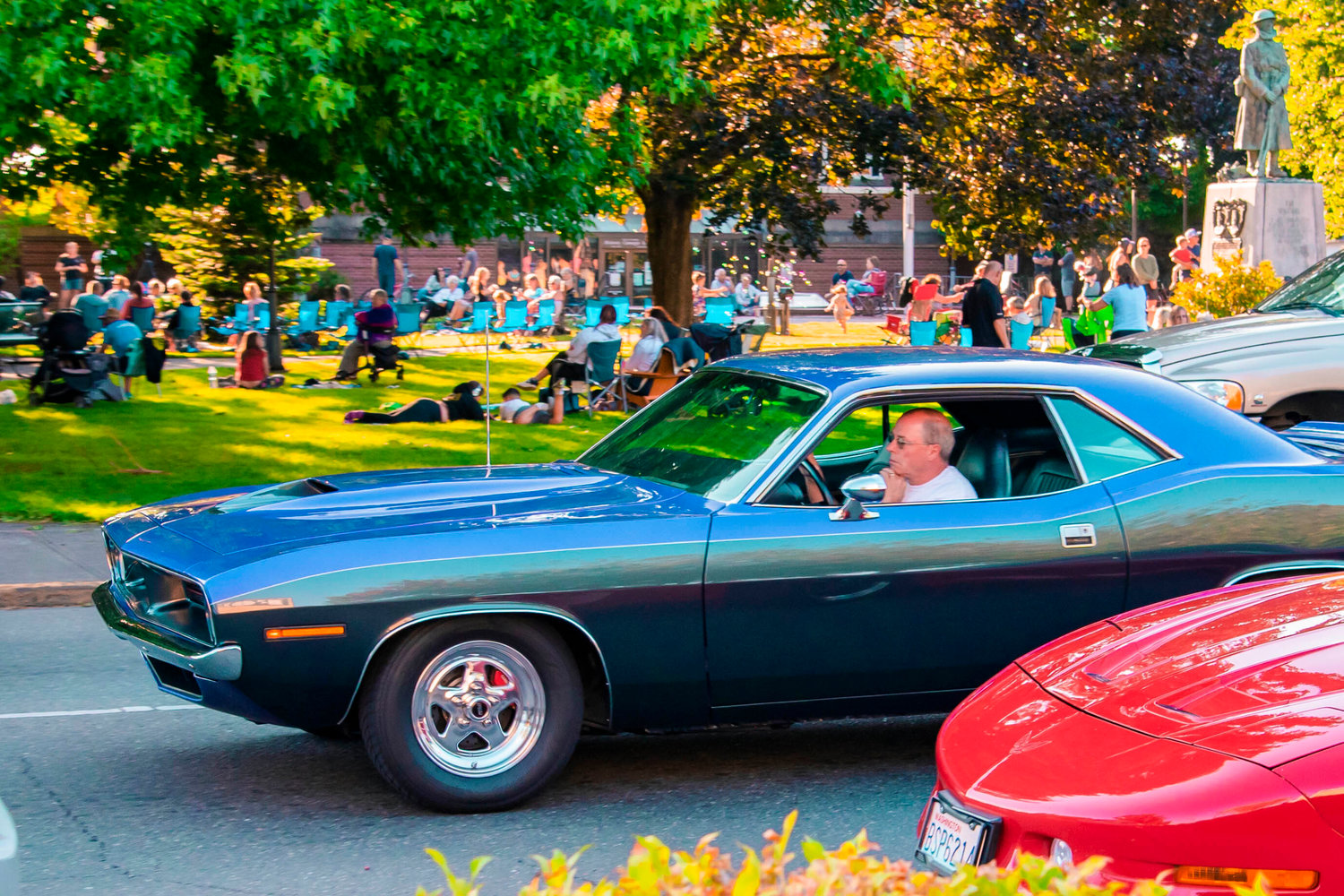 Vintage cars drive by as crowds gather for “Music in the Park” Saturday in Centralia.