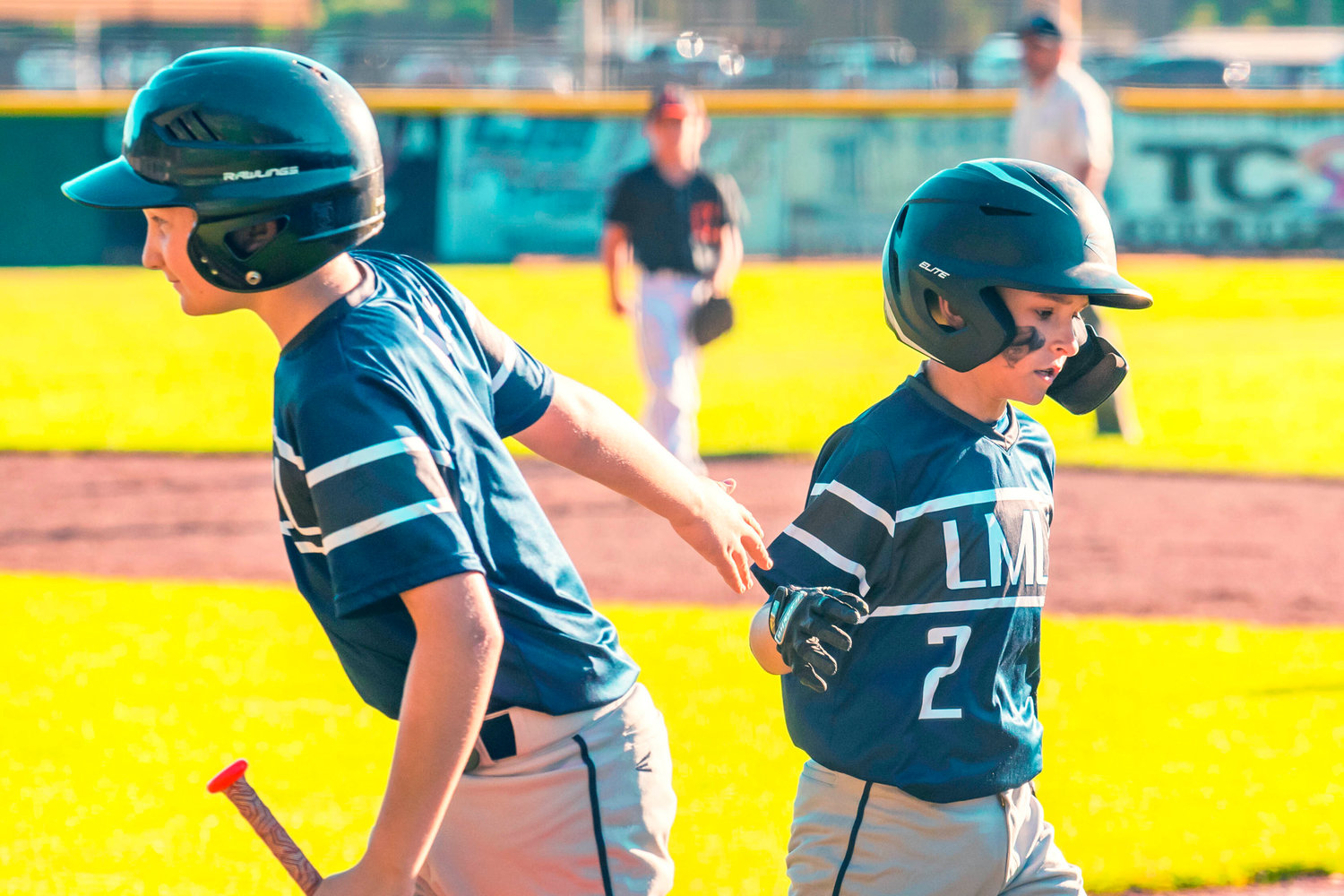 Bentley Alsonso is greeted by fellow players while returning to the dugout after scoring Thursday during the 10U Little League District 3 Championship game against Centralia.