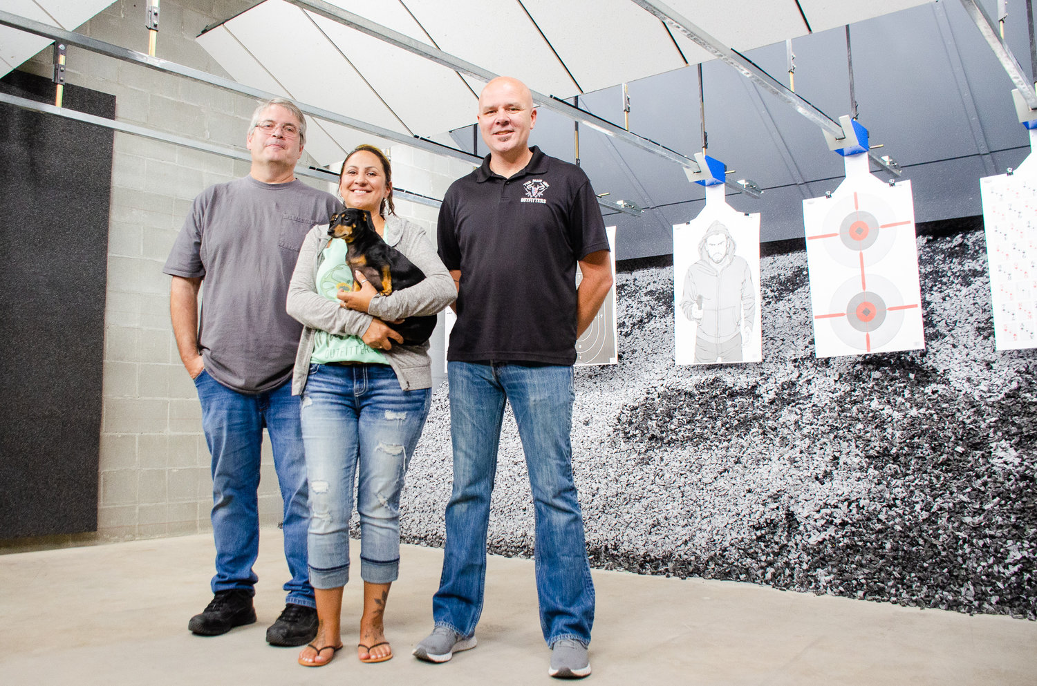 The Man Cave Outfitters co-owners, from left, Michael Irby and Shoni and Hobe Pannkuk pose for a photo Monday, July 19, inside the new indoor firing range at their Centralia business.