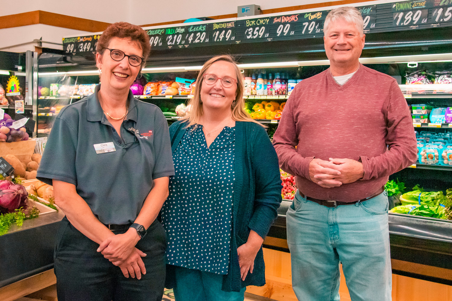 Store Director Chris Falk, Northwest Supermarkets Vice President Linda Marcott and former owner Hal Blanton smile and pose for a photo inside Blanton's Market Wednesday in Packwood.