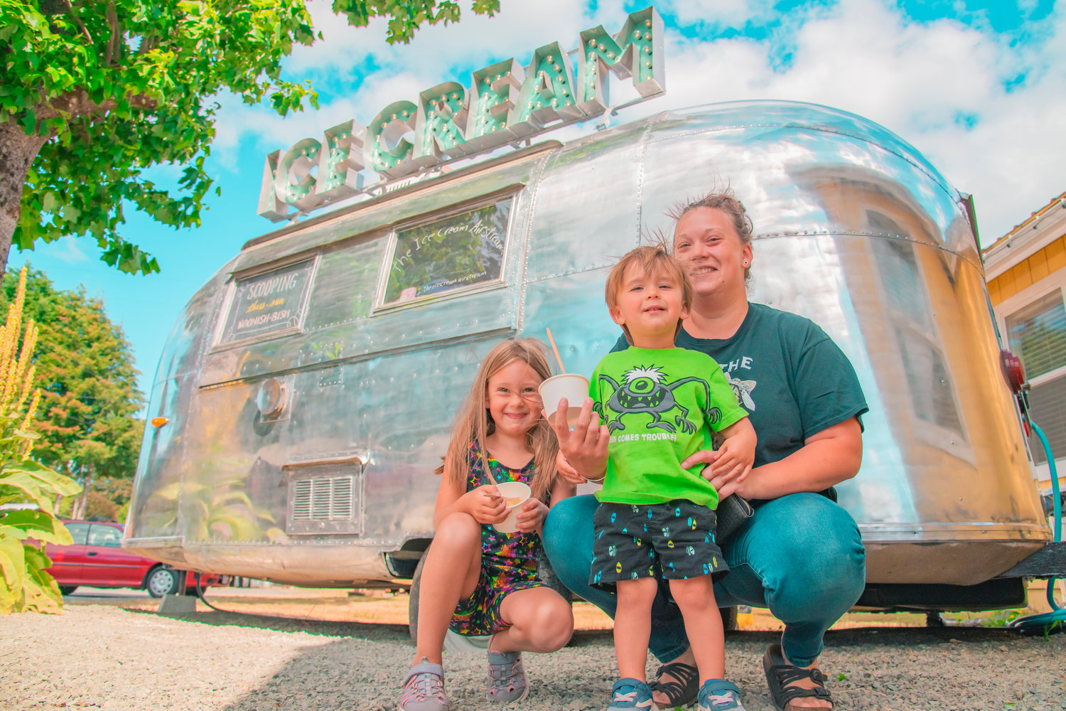 Brynlee and Bennett pose with Shayla Dollar while holding frozen treats from an Ice Cream Airstream Wednesday in Packwood.