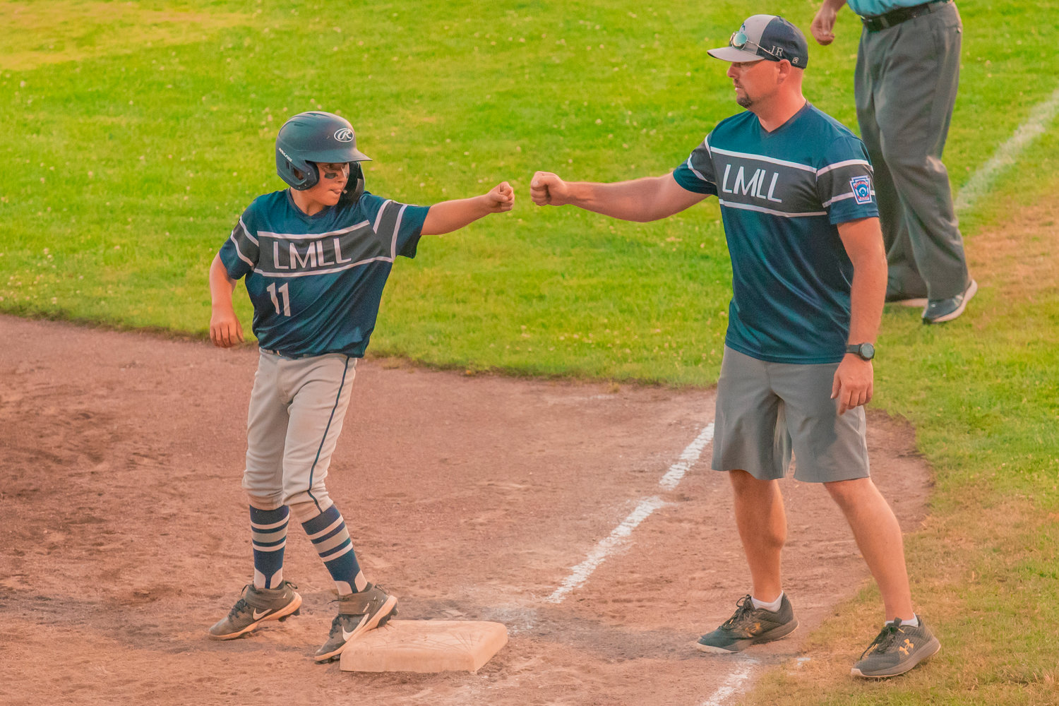 Larch Mountain's Clayton Knutson (11) fist-bumps an assistant coach on Thursday.