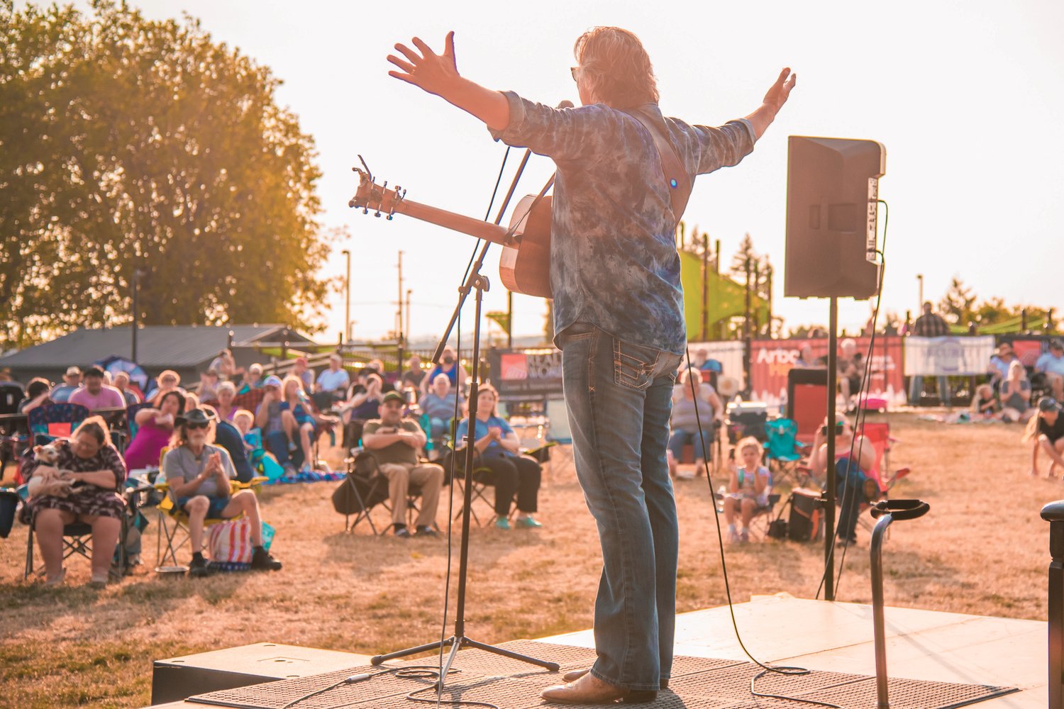 Billy Dean raises his arms after finishing a song during a Music at the Park performance in Chehalis on Friday at Recreation Park.
