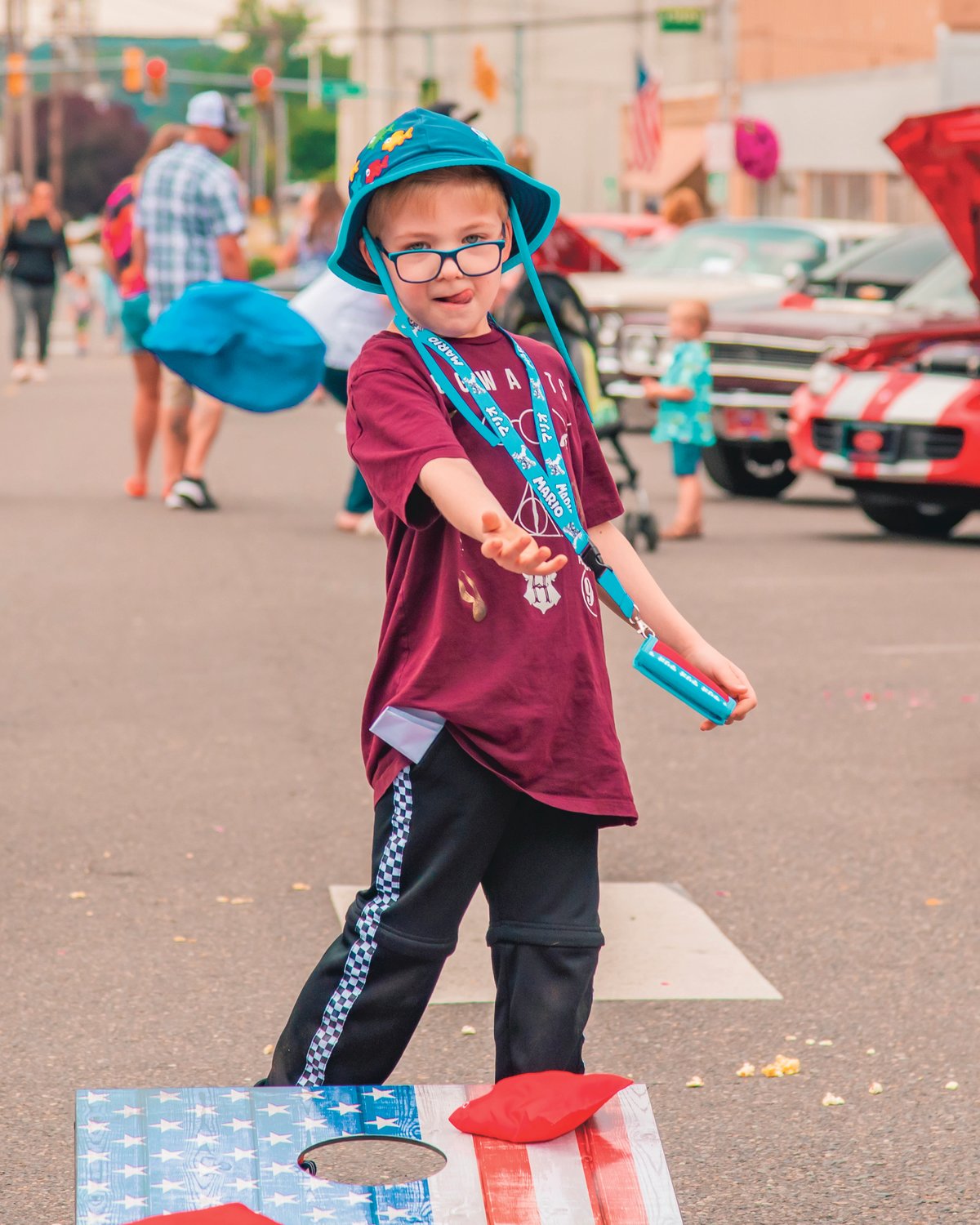 Wilder Jackson, 7, plays cornhole in the middle of NW Chehalis Avenue on Saturday during ChehalisFest.