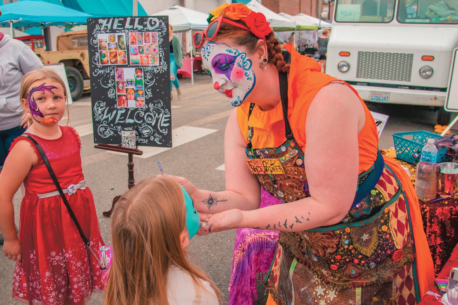 Ann McRann paints the faces of Dasee and Adelyn Muncey during ChehalisFest on Saturday.
