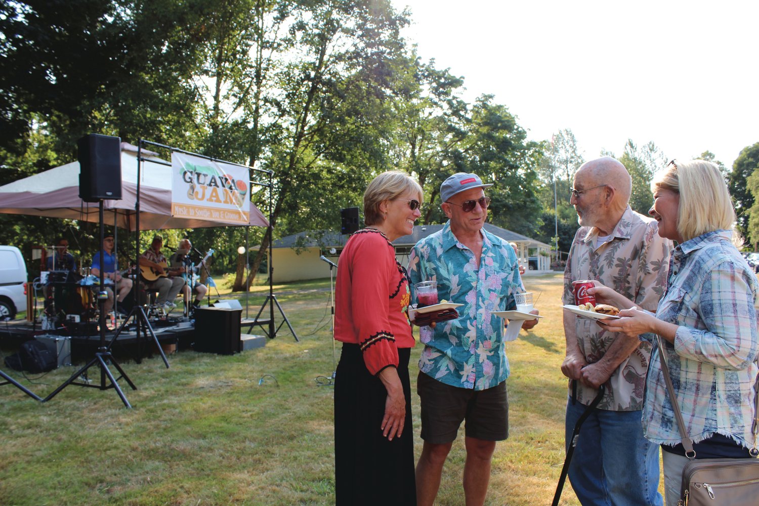 Marit Ernst and Dan Foster visit with friends John Alexander and Tiffany Alexander as the band Guava Jam plays at the Chehalis Foundation's Party in the Park fundraiser Friday night.