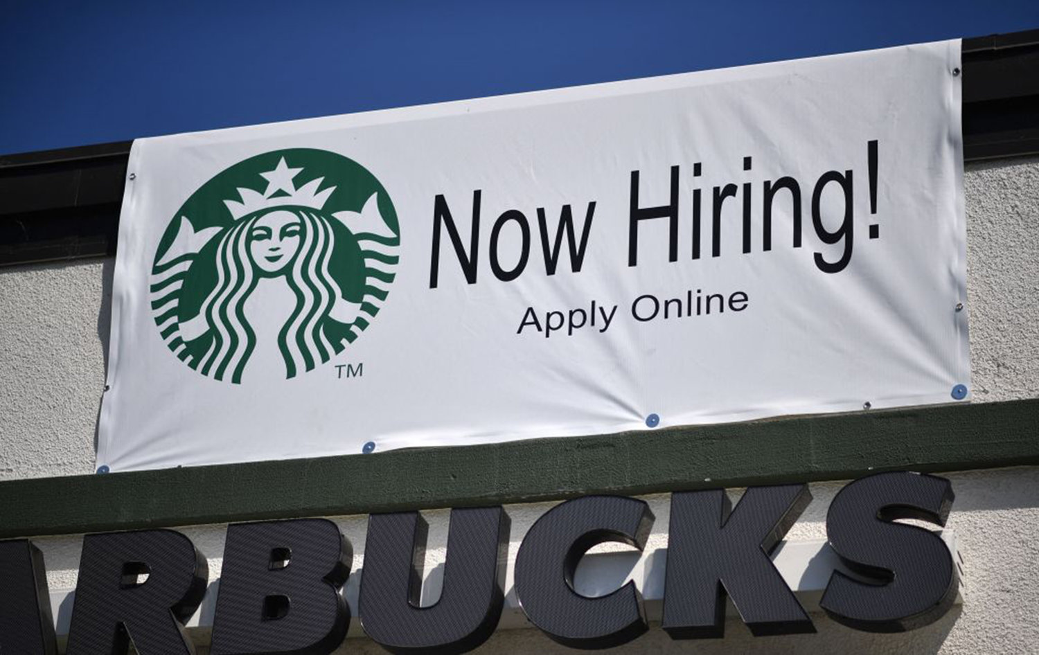 A "Now Hiring" sign is displayed outside a Starbucks drive-thru coffee shop in Glendale, California, July 7, 2021.  (Robyn Beck/AFP via Getty Images/TNS)