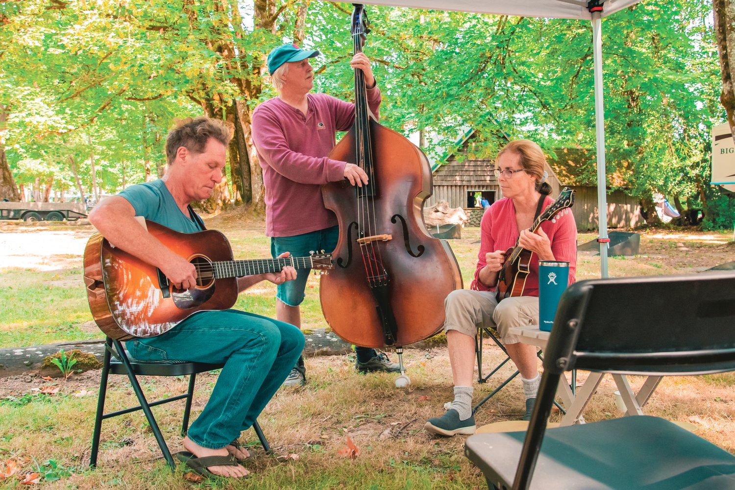 From left, Tried and Blue band members Jeff Rogell, Jeff Limbaugh, and Nancy Limbaugh play their instruments at Kemp Olsen Memorial Park during the Mount St. Helens Bluegrass Festival in Toledo in 2021.