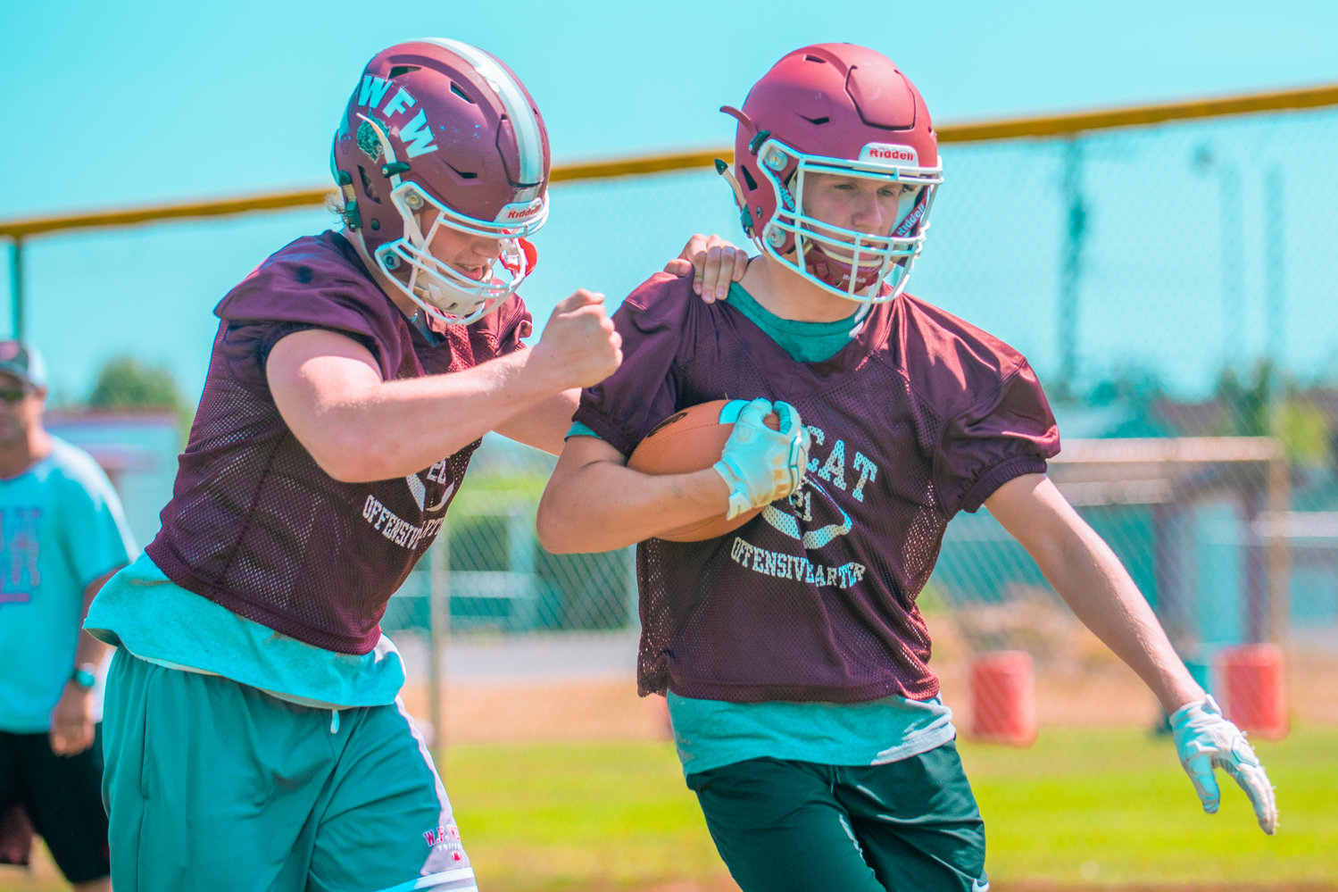Brock Guyette tries to knock the ball out of teammate Jacob Fuller's hands during W.F. West's first football practice of the season on Wednesday.