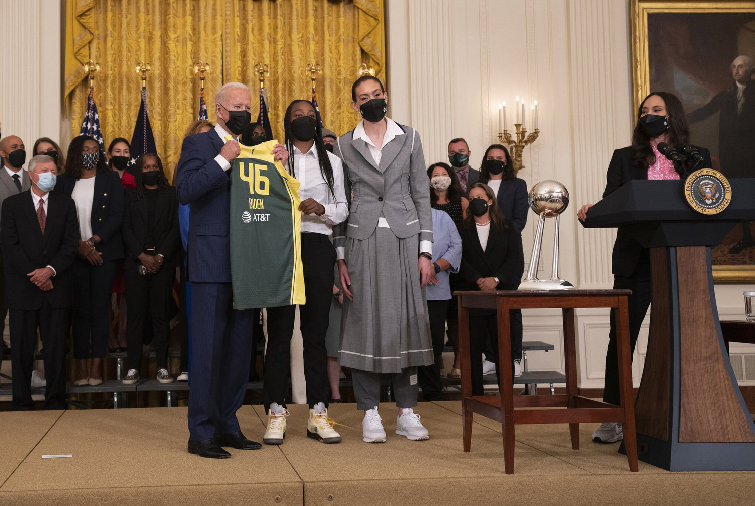 Storm players Jewell Loyd, center, and Breanna Stewart present a No. 46 jersey to President Joe Biden on Monday during a White House ceremony celebrating their 2020 WNBA championship.