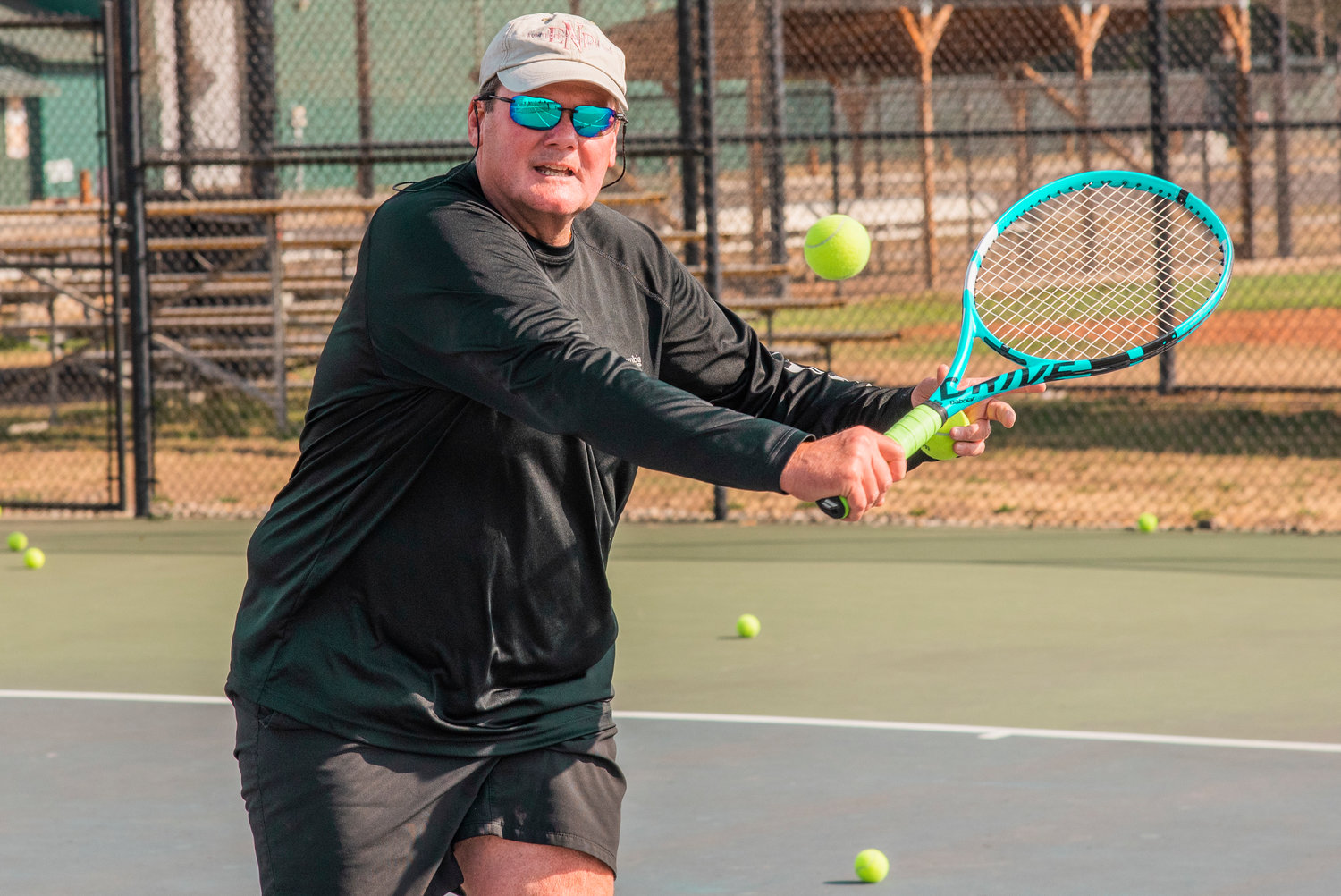 Centralia Tennis Coach Scott Snyder swings his racket during practice near Tiger Stadium in Centralia on Tuesday.