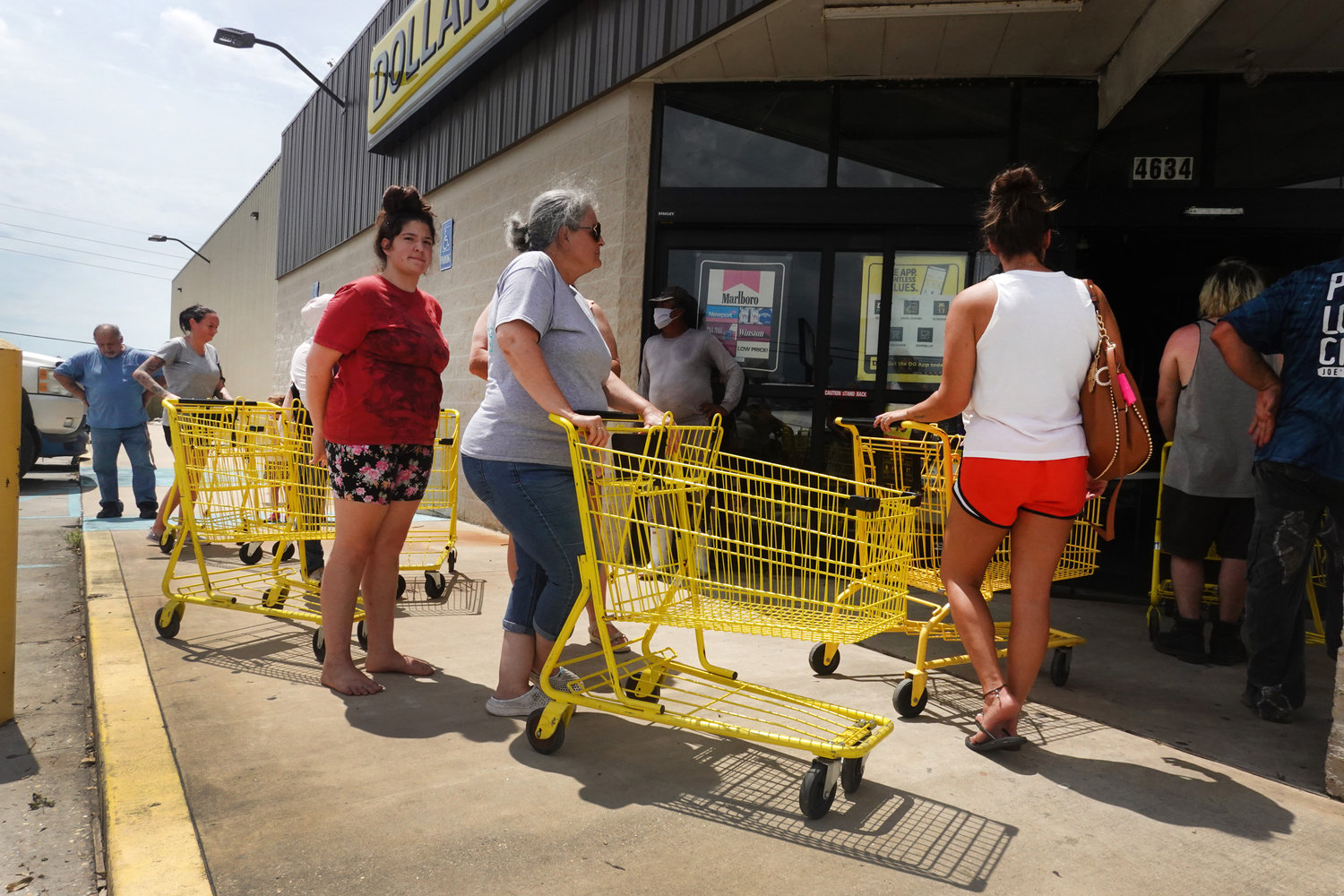 People wait in line to buy supplies at a Dollar Store that opened despite having no power following Hurricane Ida on Tuesday, August 31, 2021 in Houma, Louisiana.  Ida made landfall August 29, as a Category 4 storm southwest of New Orleans. (Scott Olson/Getty Images/TNS)