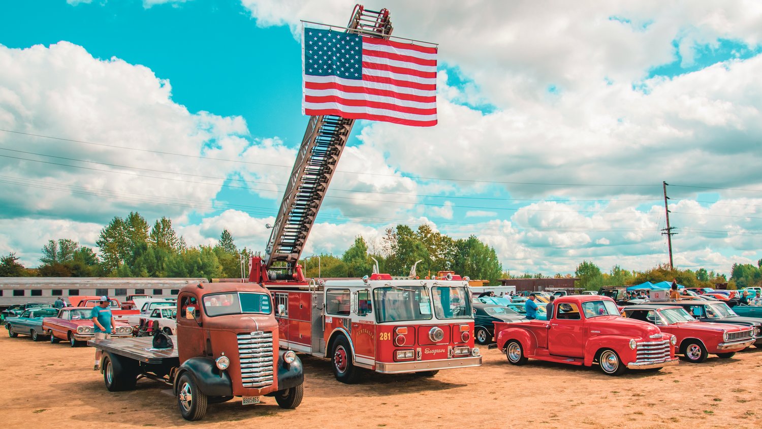 A Centralia ladder truck displays the American Flag over the Rust or Shine Car Show and Music Festival in Chehalis Sunday afternoon.