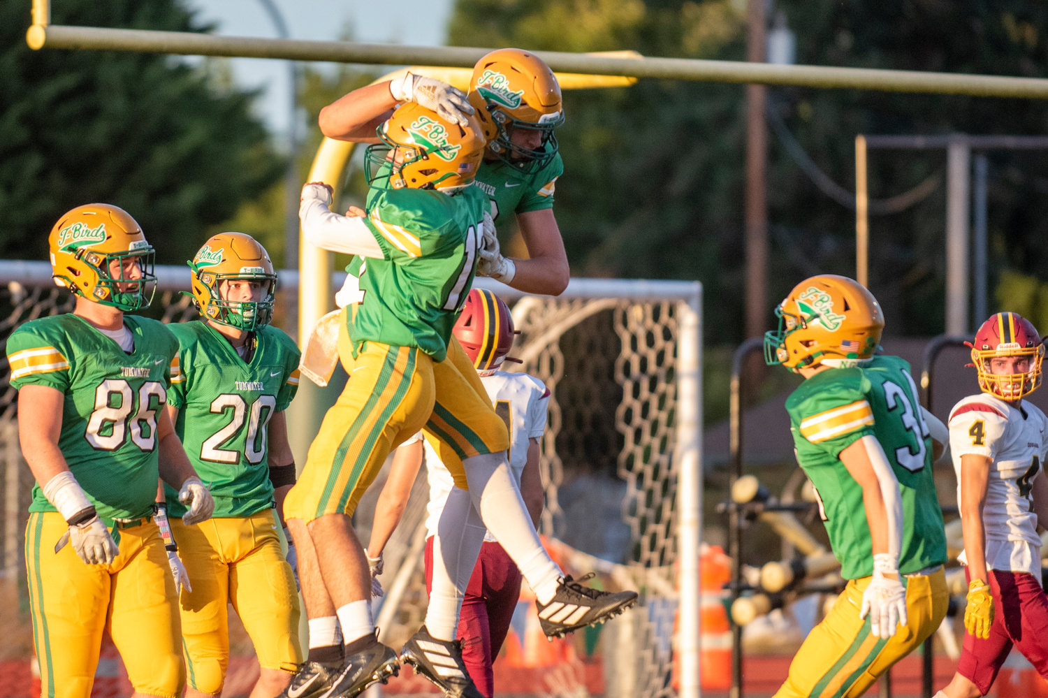 Tumwater tight end Ryan Otton, middle right, leaps to celebrate his long touchdown reception on the Thunderbirds' opening drive against Capital on Thursday.