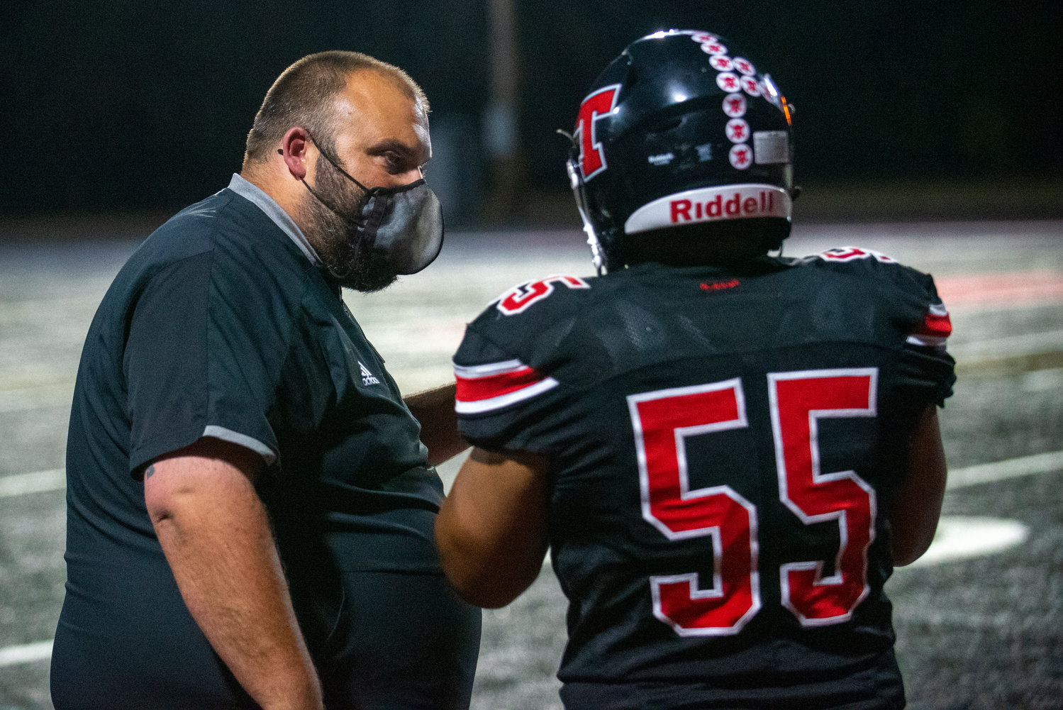 Tenino coach Cary Nagel talks with lineman Andres Capilla-Zumido (55) during the third quarter of Friday's home game against North Beach.