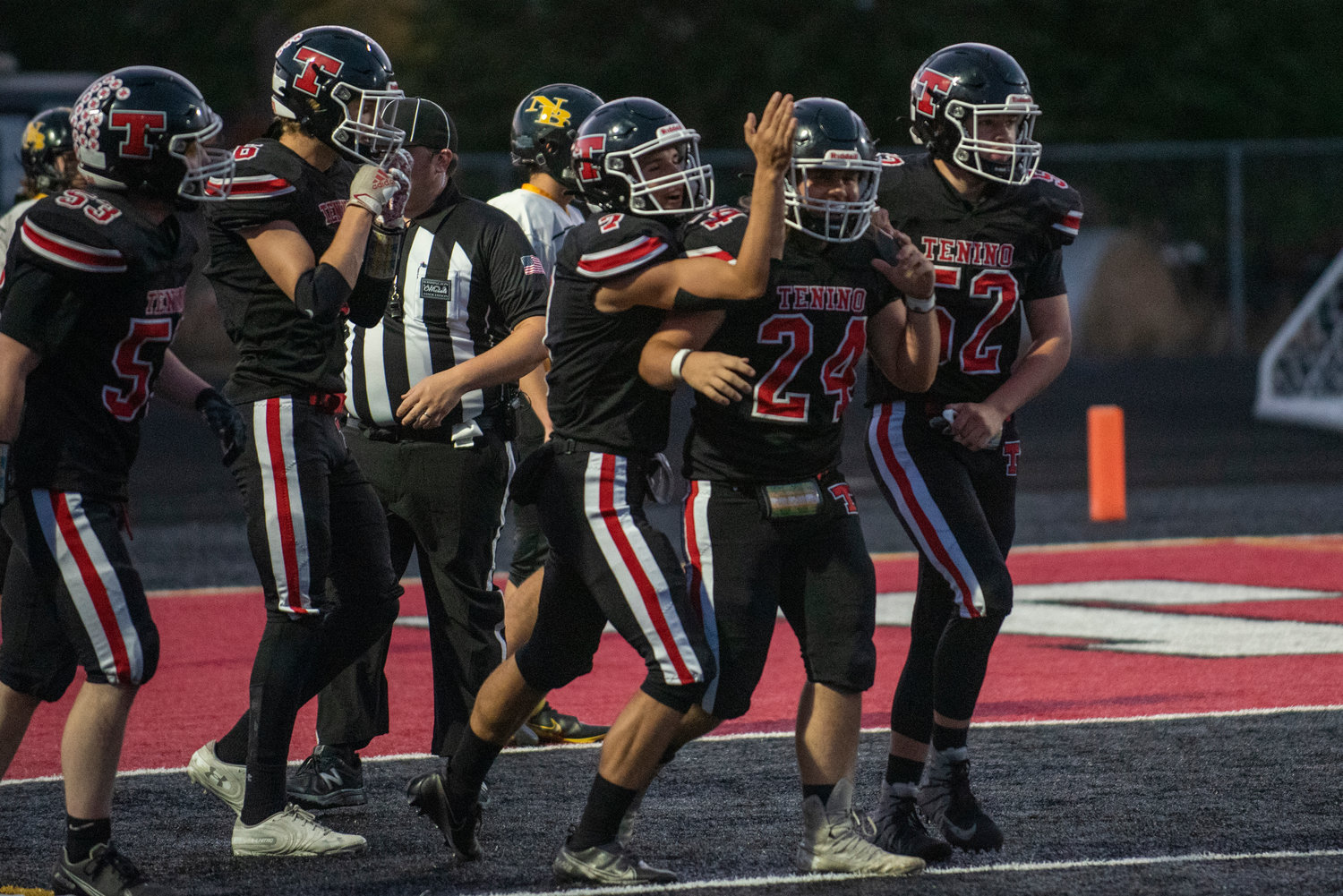 Tenino's Shawn Nicholson(24) is hounded by teammates after scoring on a long touchdown run against North Beach on Friday.