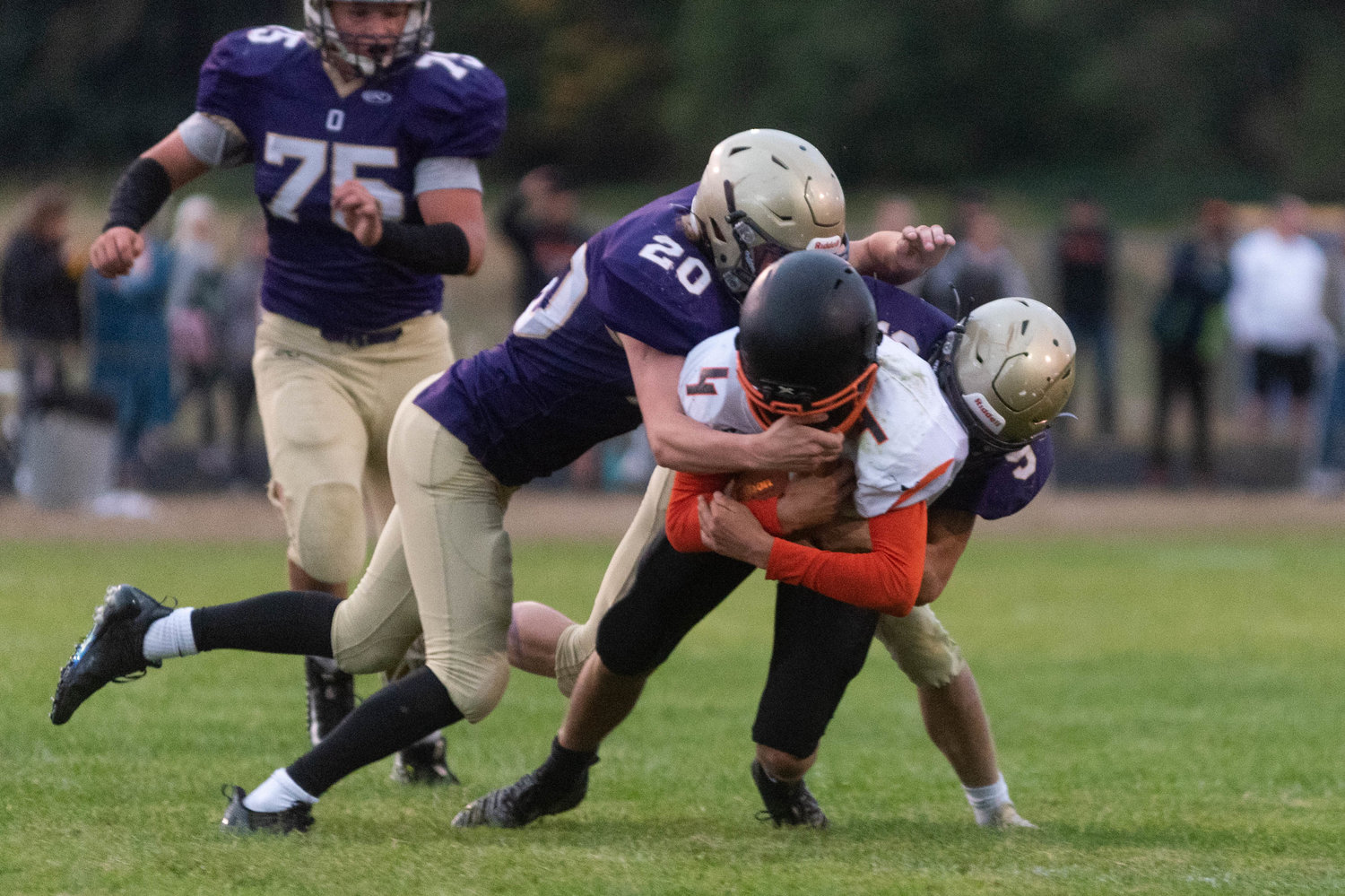 Napavine quarterback Ashton Demarest is brought down by two Onalaska defenders in the Tigers win over the Loggers Friday night.