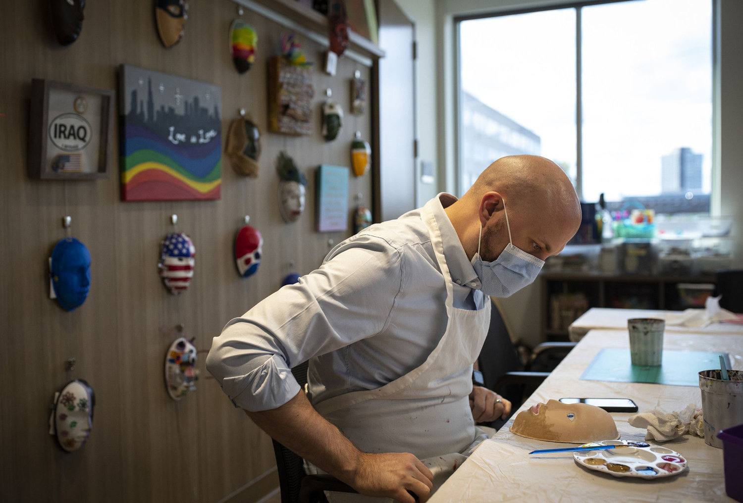 Jarrett Langfitt, a therapist with the Road Home Program who served five years in the army, paints a mask in an art therapy workshop on Sept. 9, 2021. (E. Jason Wambsgans/Chicago Tribune/TNS)