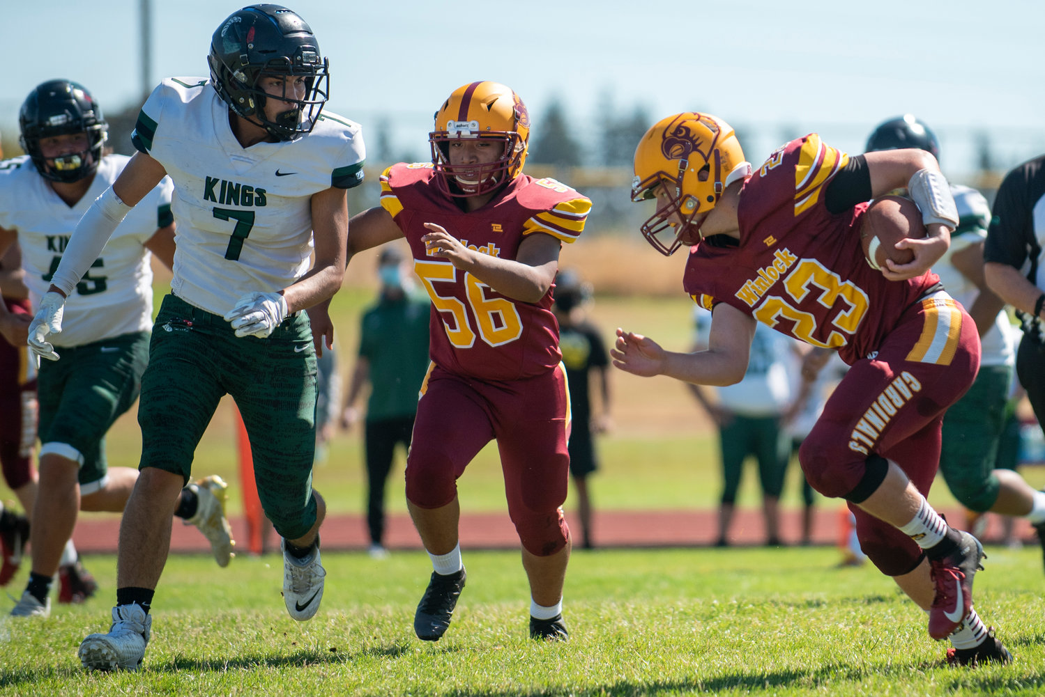 Winlock's Neal Patching (23) lowers his head as he runs toward a Muckleshoot Tribal player, with Xavier Barragan (56) in the background, on Saturday.