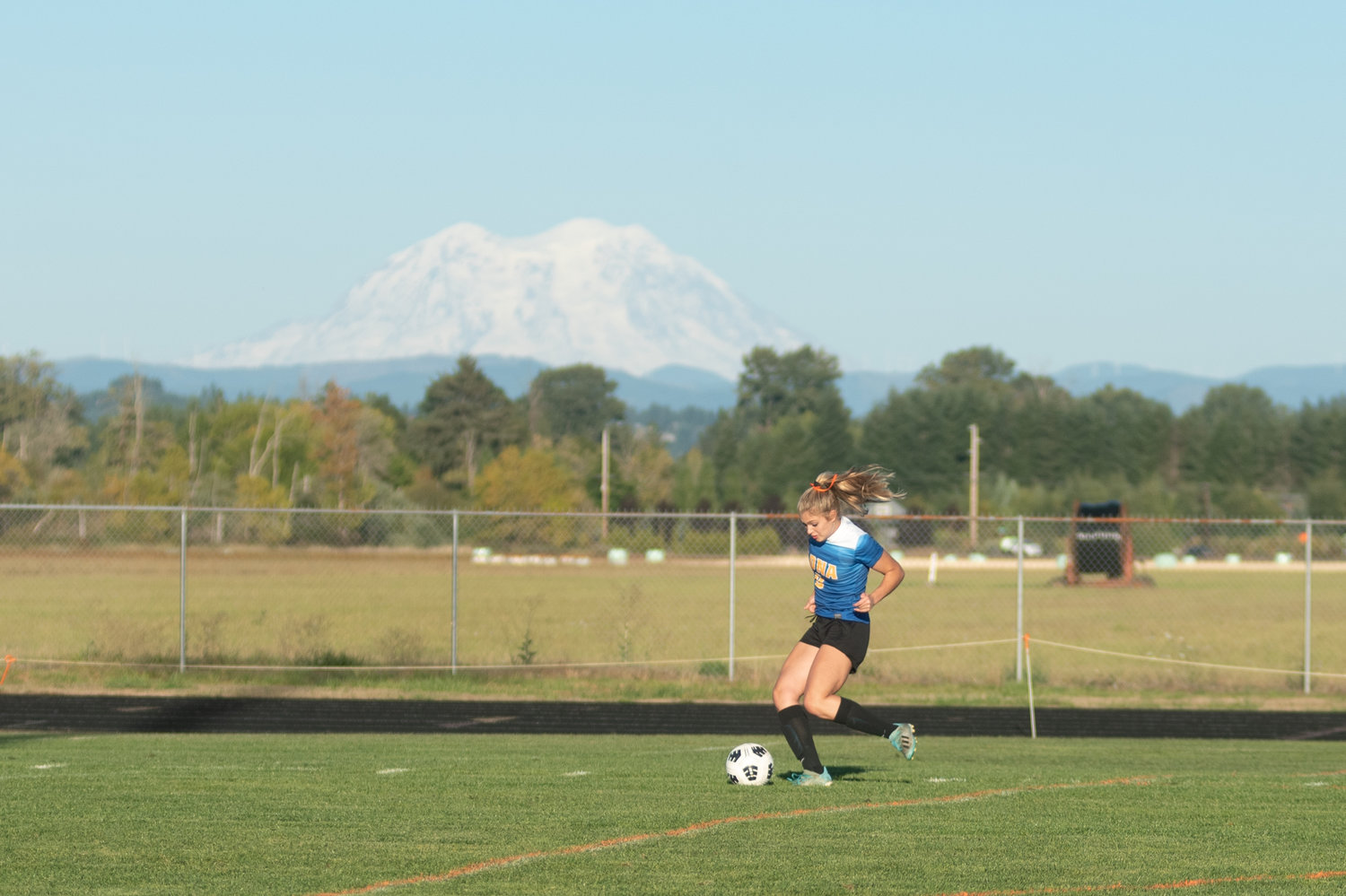 An Adna player shoots a ball toward the net during a drill pregame against Onalaska in the shadow of Mount Saint Helens.