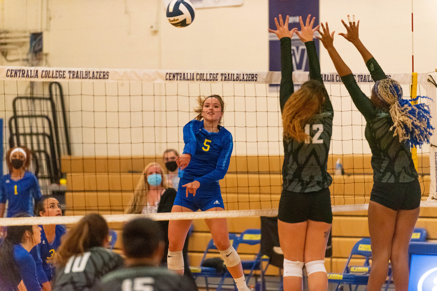 Centralia College's Kate Demery (5) spikes the ball past two Highline blockers during the Blazers' home opener on Wednesday.
