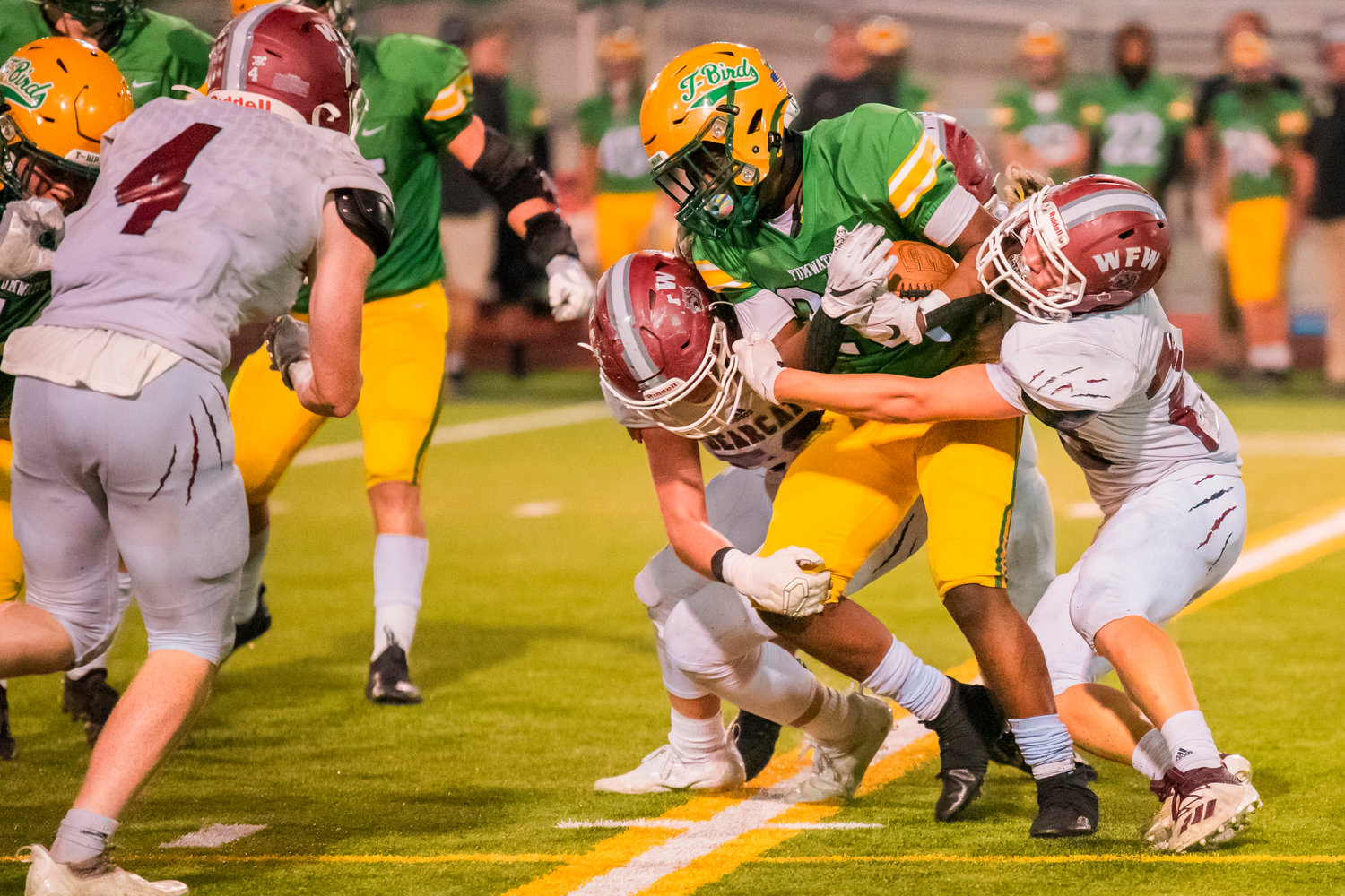 Tumwater’s Carlos Matheny (25) is wrapped up by Bearcat defenders while running with the football during a game Friday night.