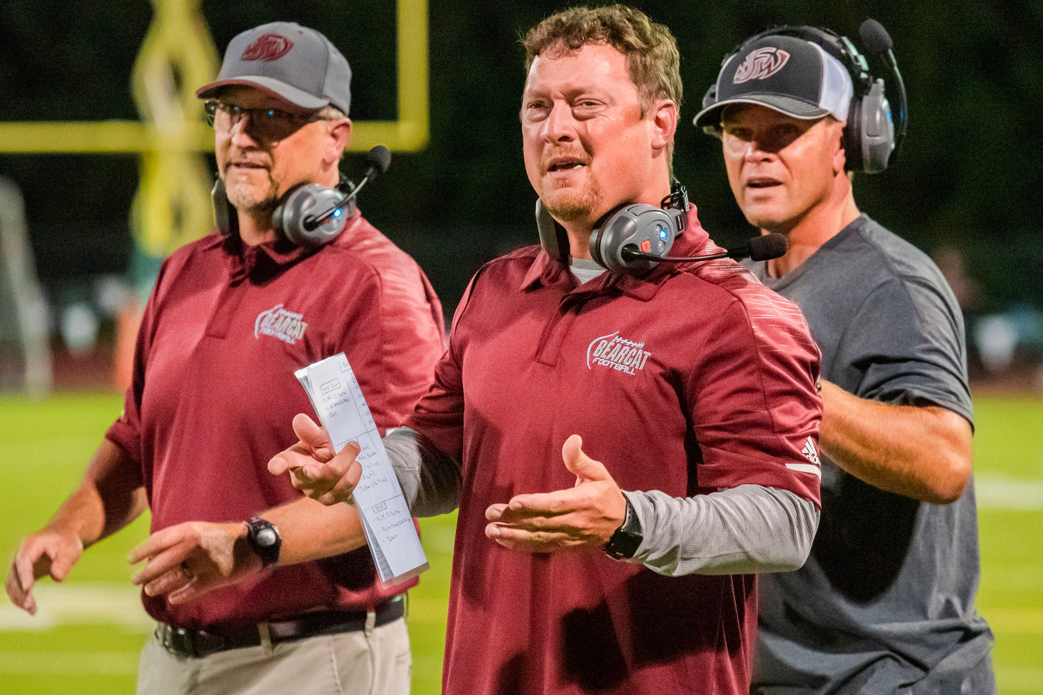 Bearcat’s Head Coach Dan Hill is joined by staff while questioning a flag on the field following a play Friday night.