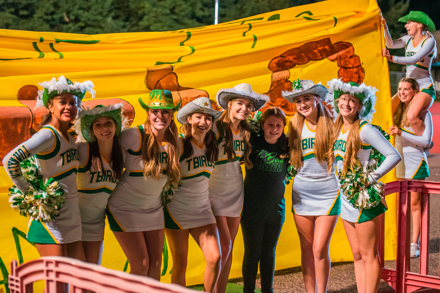 Tumwater cheerleaders pose for a photo at halftime under Friday night lights.