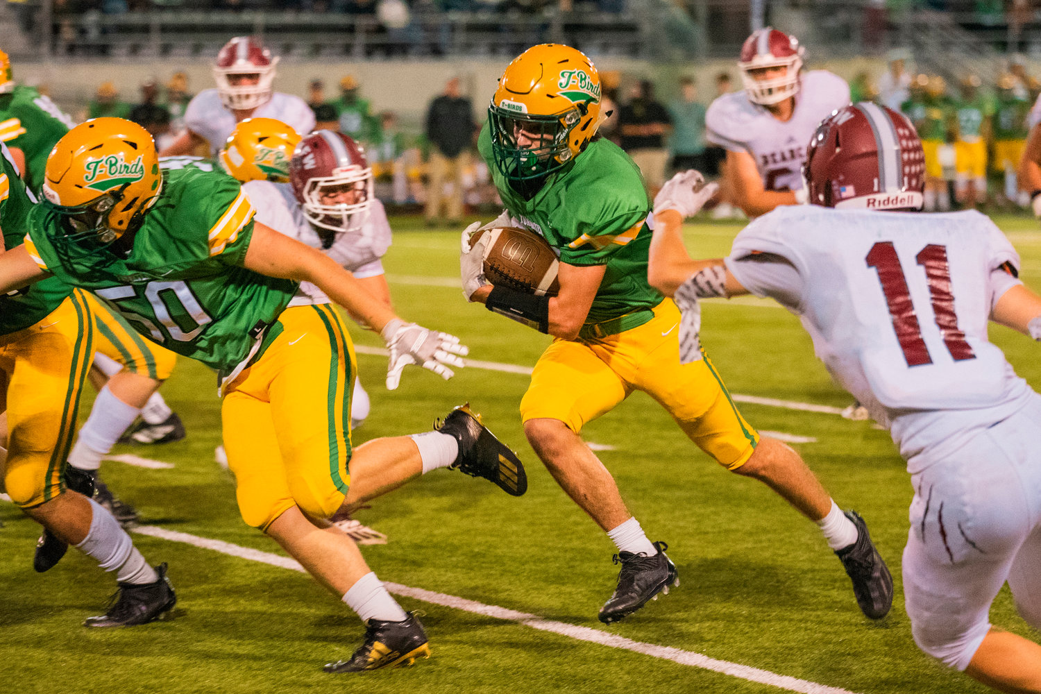 Tumwater’s Kai McLeod runs with the football past defenders Friday night during a game against W.F. West.