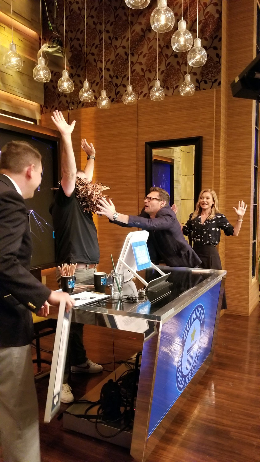 Ryan Seacrest touches the pencils that Joel Strasser placed in his beard as he was breaking the world record for the activity on the Kelly and Ryan show.