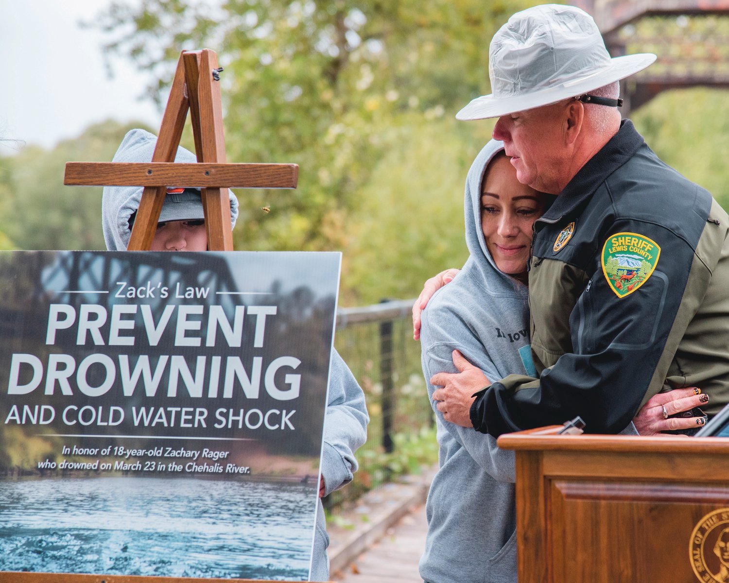Sheriff Rob Snaza embraces Kim Rager during an event raising awareness around cold water shock and honoring the life of her son Zachary Rager who drowned March 23 in the Chehalis River.
