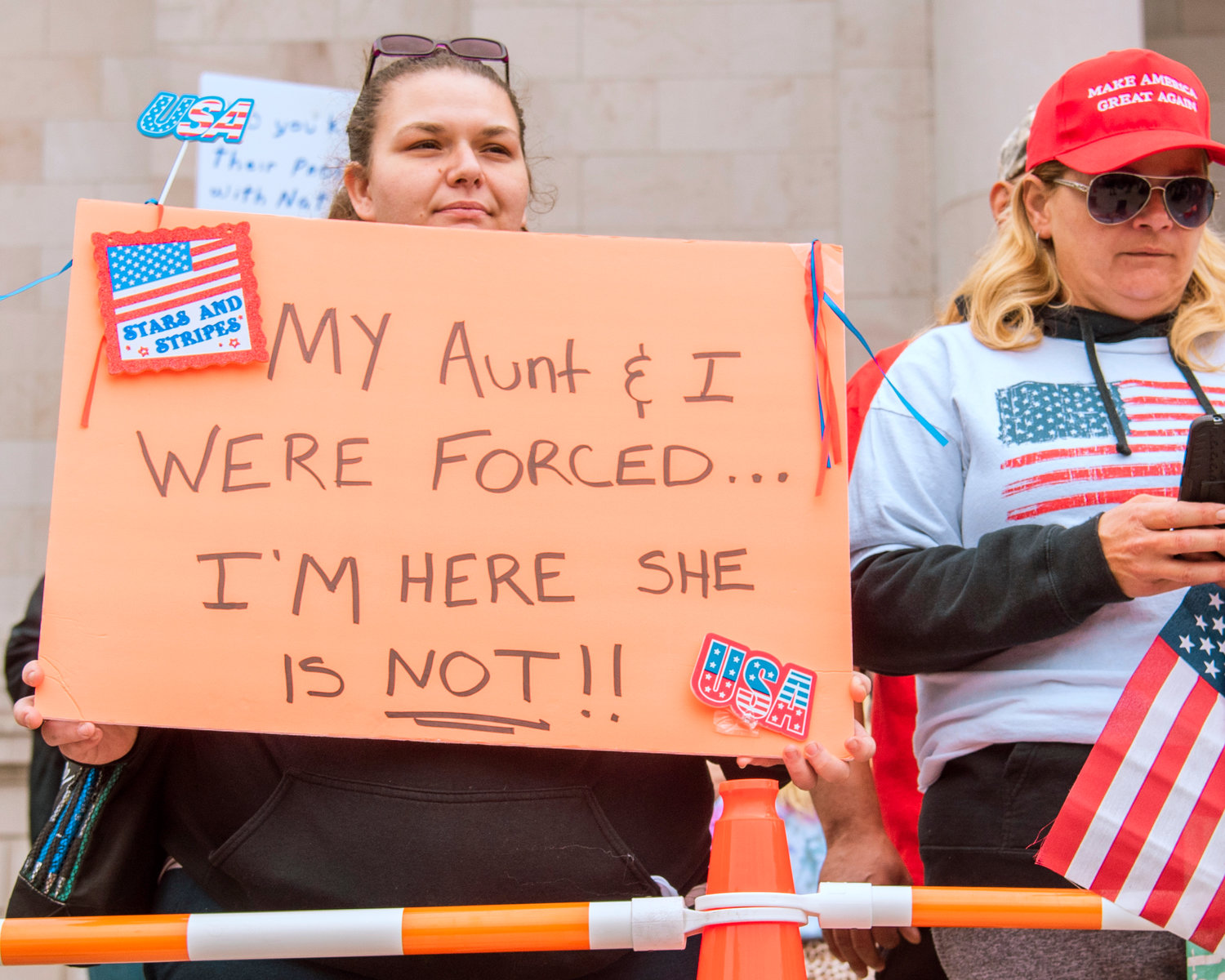 A sign reads, “My aunt and I were forced…I’m here she is not,” outside the Washington State Capitol Building during a “Medical Freedom Rally” in Olympia on Sunday.