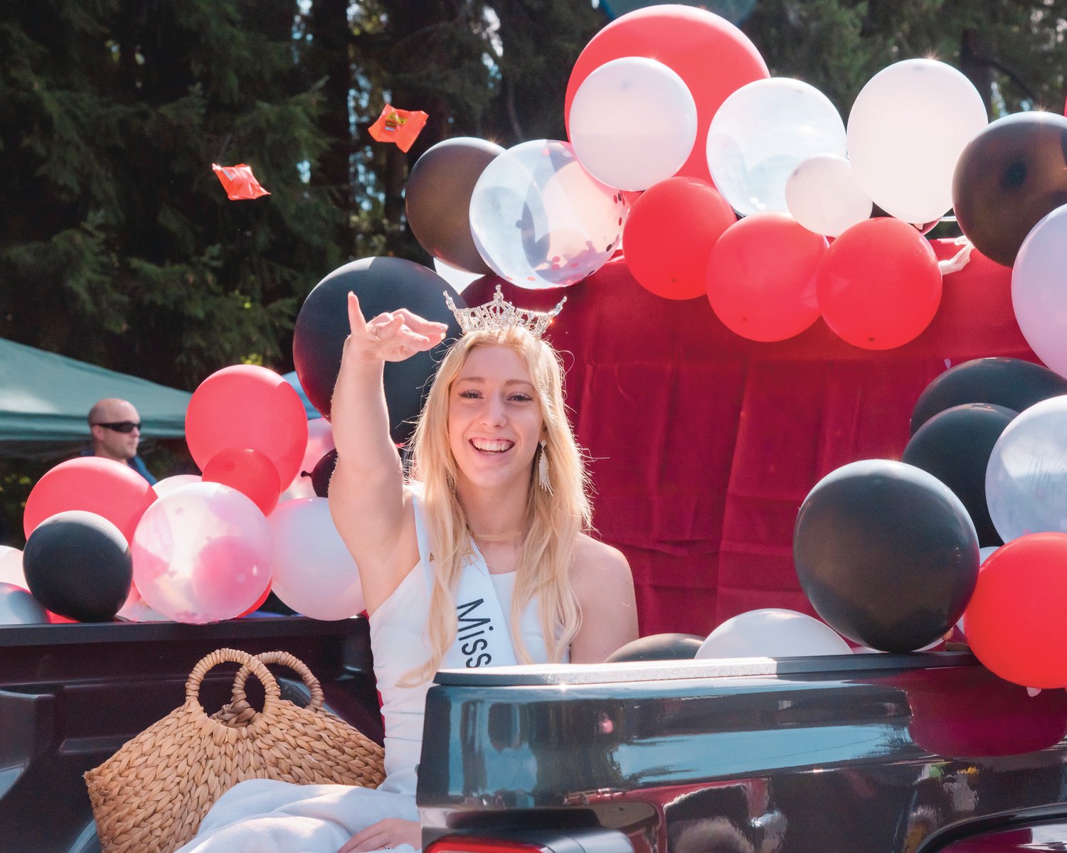 Miss Lewis County Sophie Moerke smiles and throws candy from a float during the Onalaska Apple Harvest Parade Saturday morning.
