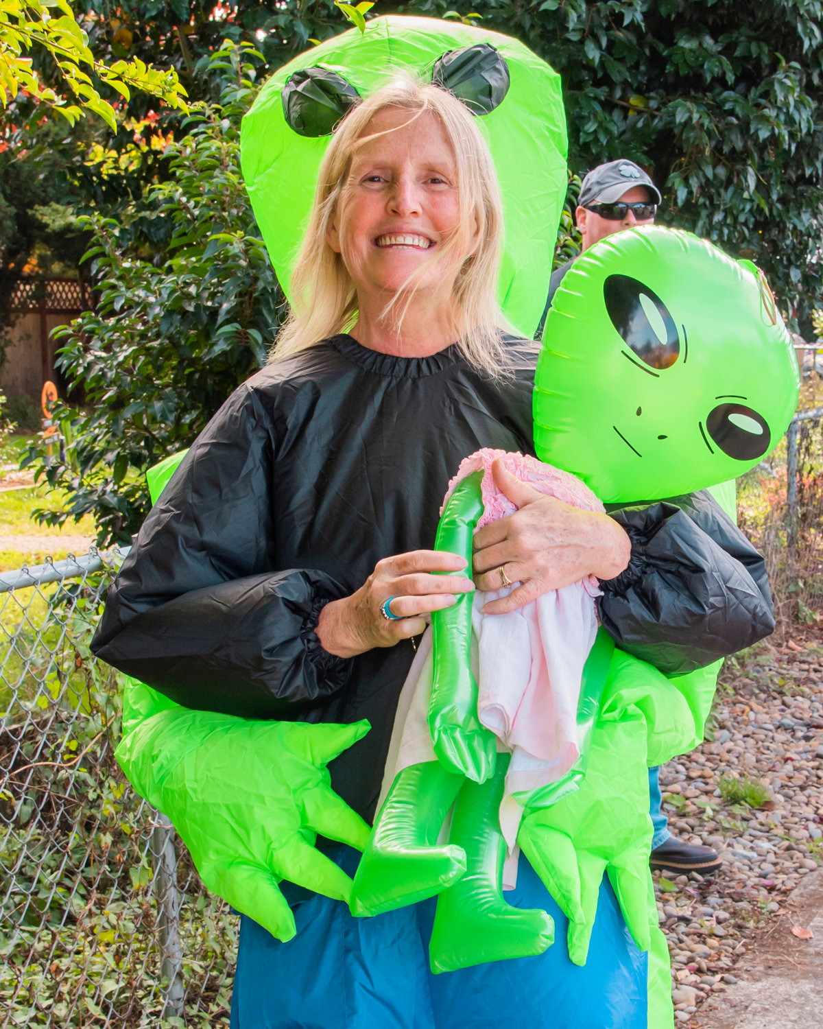 Linda Rozier smiles and poses for a photo while attending the Onalaska Apple Harvest parade holding an alien and dressed as an abductee Saturday morning.