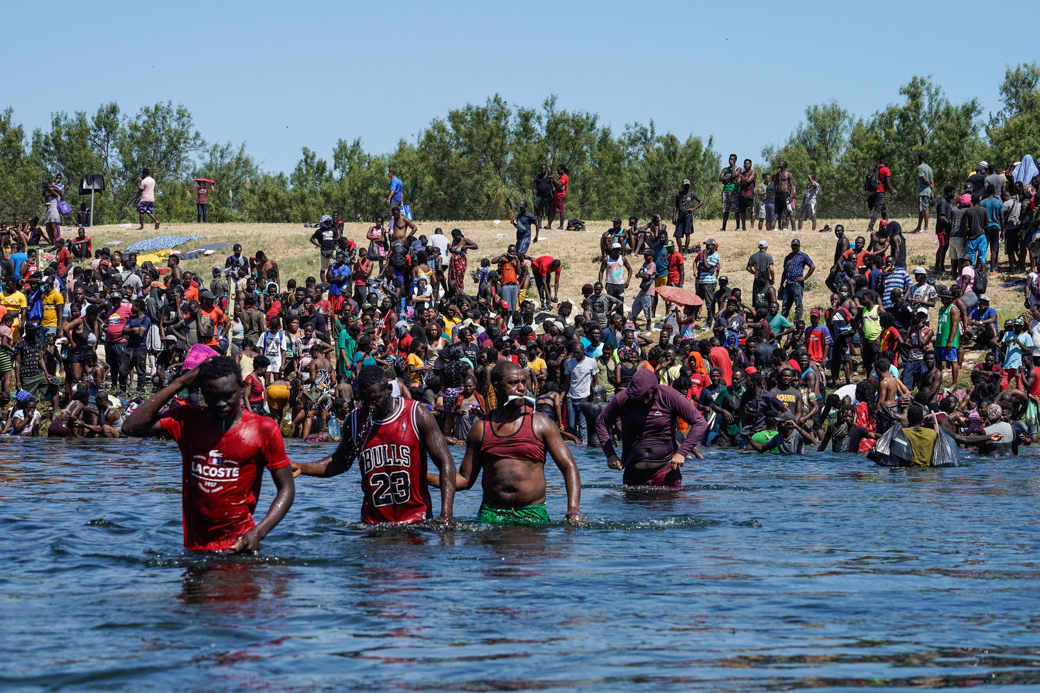 Haitian migrants cross the Rio Grande river to get food and water in Mexico, after another crossing point was closed near the Acuna Del Rio International Bridge in Del Rio, Texas on Sept. 19, 2021. (Paul Ratje/AFP/Getty Images/TNS)