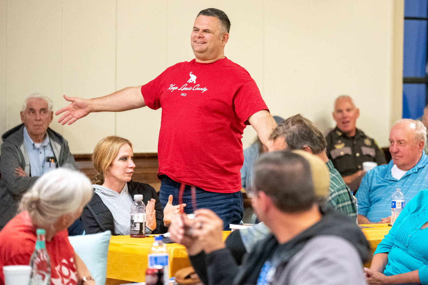 Morton Police Chief Roger Morningstar smiles and stands while sporting a shirt that reads, “Keep Lewis County Red” during a Lewis County Republicans meeting on the topic of filling the District 3 Commissioner position.