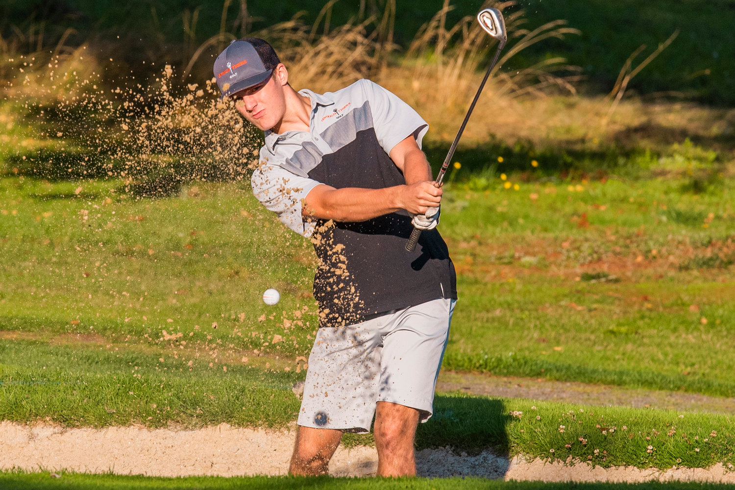 Centralia’s Brady Sprague swings out of a bunker Thursday at Riverside Golf Course in Chehalis.